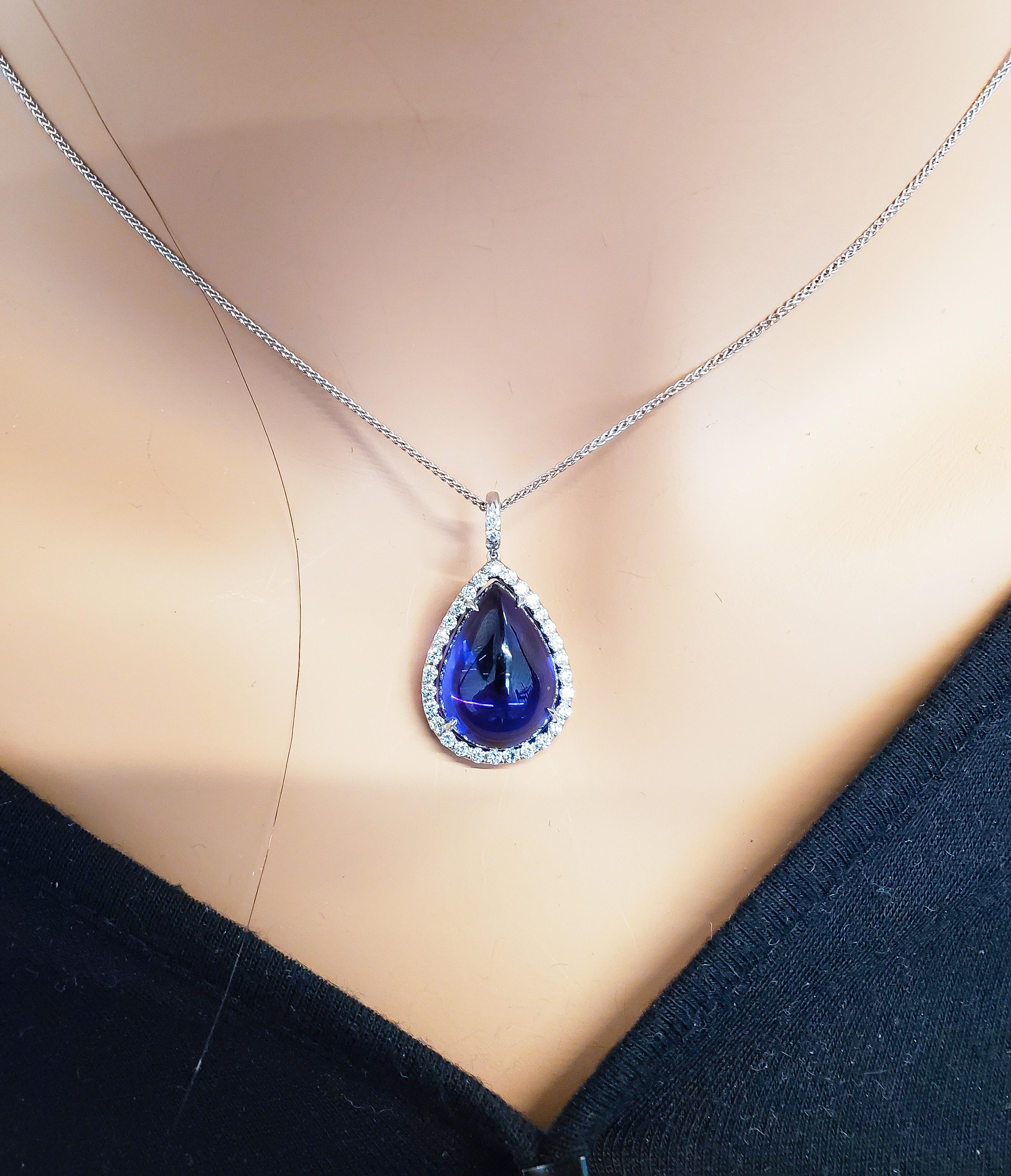 Inspired by vintage styles, this gorgeous brightly polished 18 karat white gold teardrop pendant features one pear cabochon smooth finish sugar loaf tanzanite prong set it the center displaying a vibrant fine bluish-purple color. This precious
