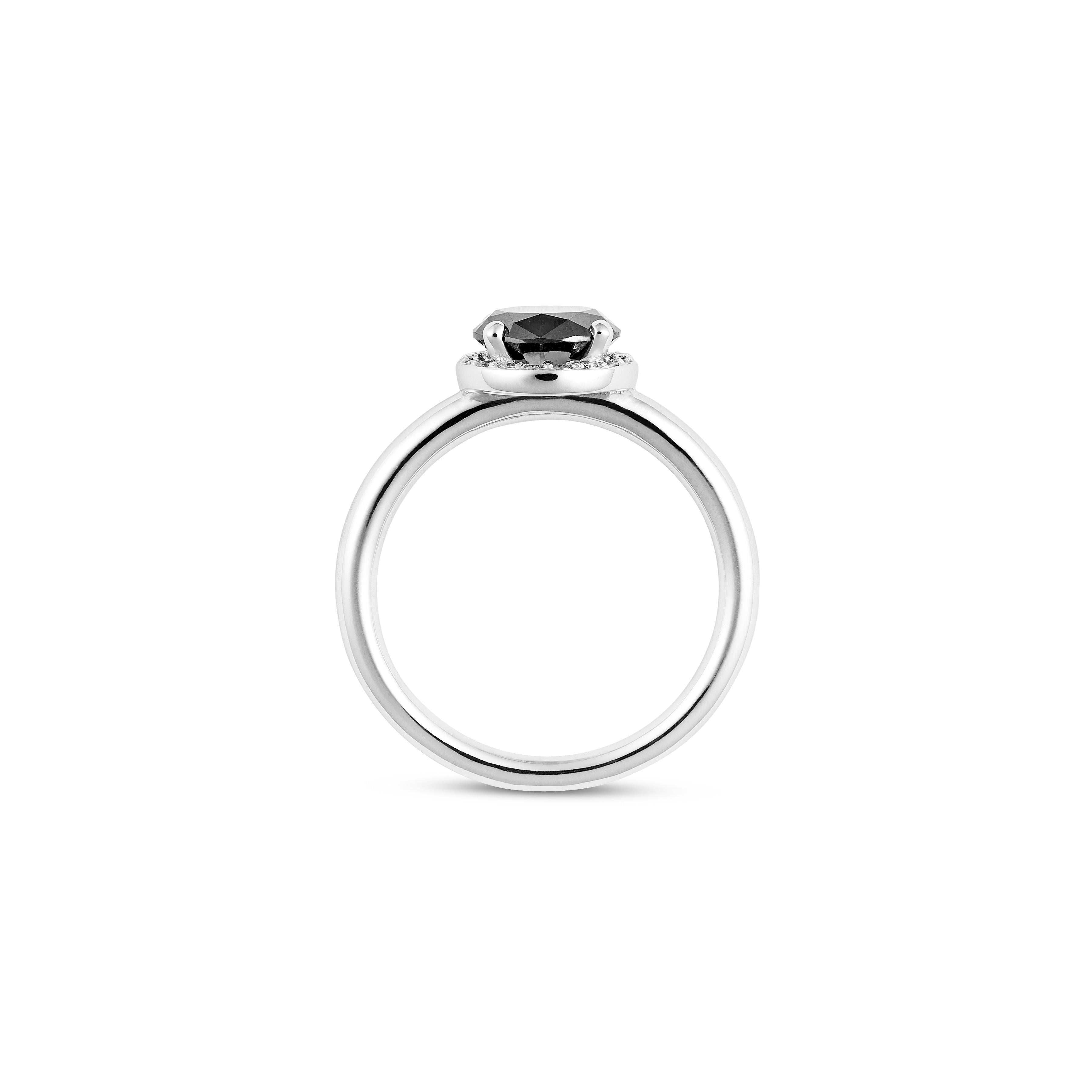 Handcrafted in 18ct white gold this black and white diamond engagement ring is an enigmatic natural-colour black diamond. Revered for its unique and dramatic beauty designed in a fine halo setting circled by collection quality micro-pave set round