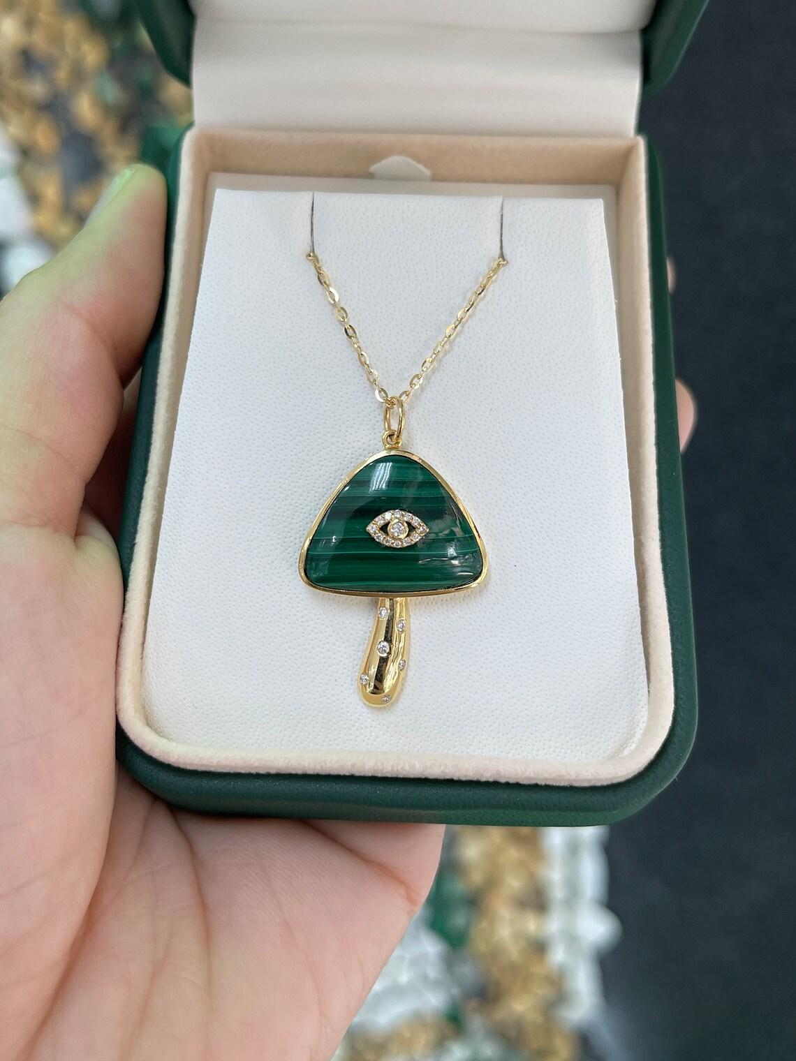 Embrace the whimsical charm of our Mushroom Pendant, a nature-inspired adornment that seamlessly blends luxury and playfulness. The head of the mushroom boasts a stunning 15.30-carats of malachite, bezel-set in 14k gold, and crowned with an