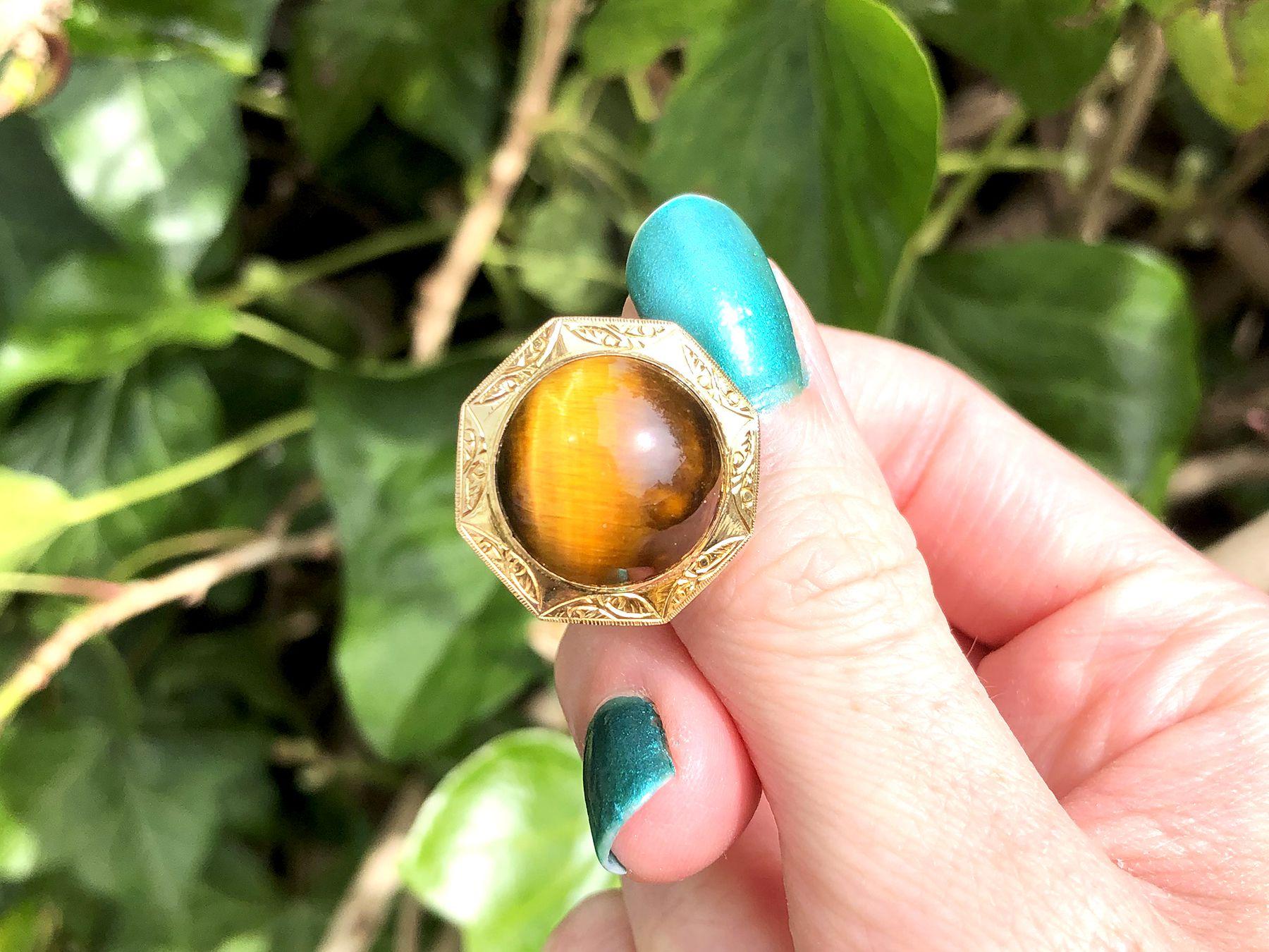 A fine and impressive pair of vintage 15.46 carat tigers eye and 14 karat yellow gold cufflinks; an addition to our mens jewelry and estate jewelry collections.

These impressive vintage cabochon cut cufflinks have been crafted in 14k yellow