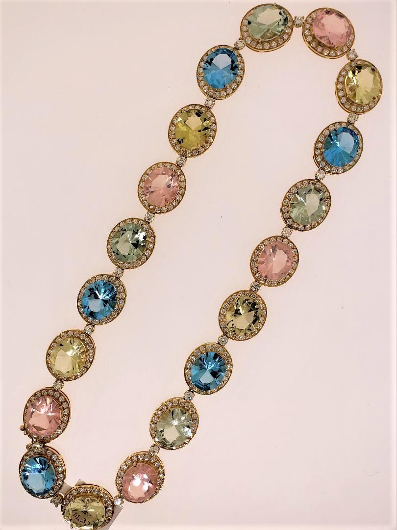 Designed and manufactured by Michael Engelhardt, this multi colored necklace was created in 18 Karat Yellow Gold.  The featured stones of 5 Blue Topaz, Green Amethyst, Yellow Quartz and Rose Quartz (total weight of the gemstones 155.7 carats) are