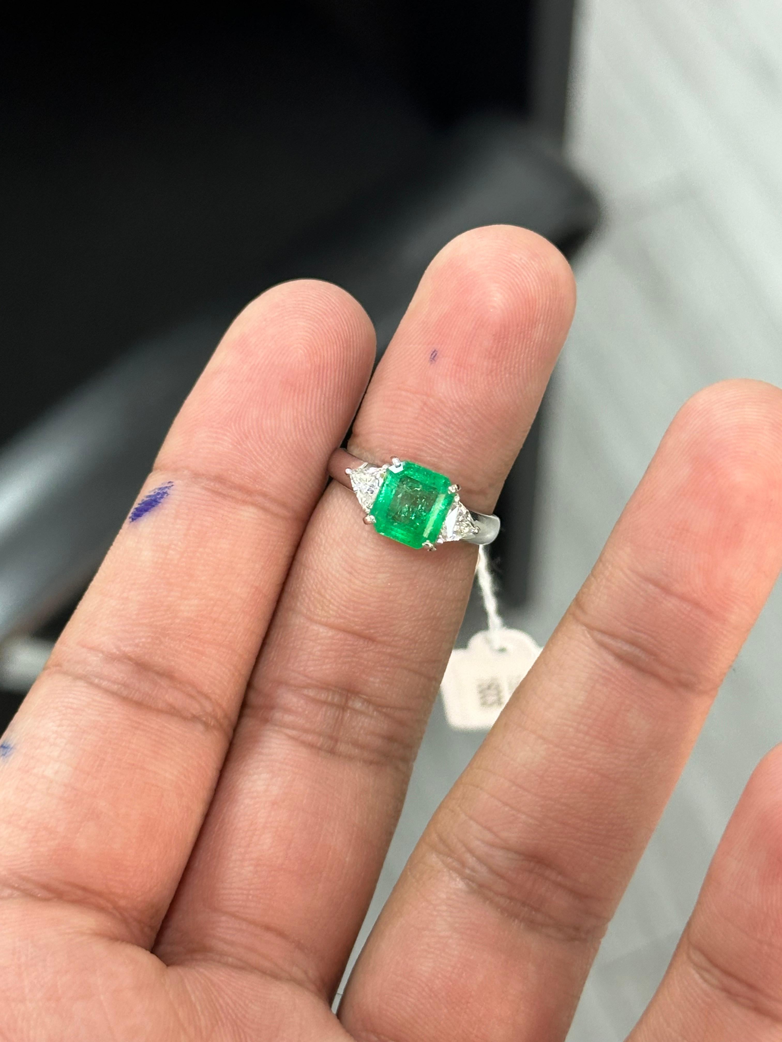 Introducing the epitome of luxury and sophistication, behold the breathtaking three-stone, Emerald and Diamond Ring, a true marvel in the world of fine jewelry. Crafted with precision and passion, this extravagant piece exudes opulence from every