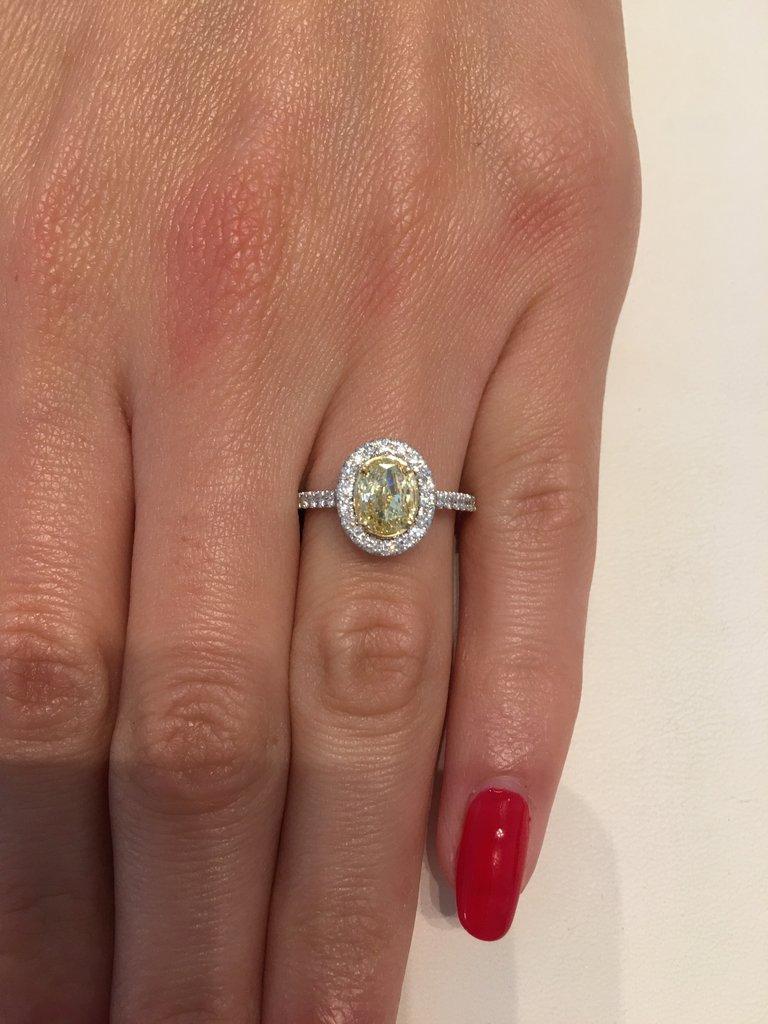 This 1.55 amazing fancy yellow diamond engagement ring is hand crafted to perfection. The magnificent 1.00ct oval cut center diamond is GIA Certified at Fancy Yellow SI2. It has a vibrant canary yellow color and it is eye clean! The cut and shape of