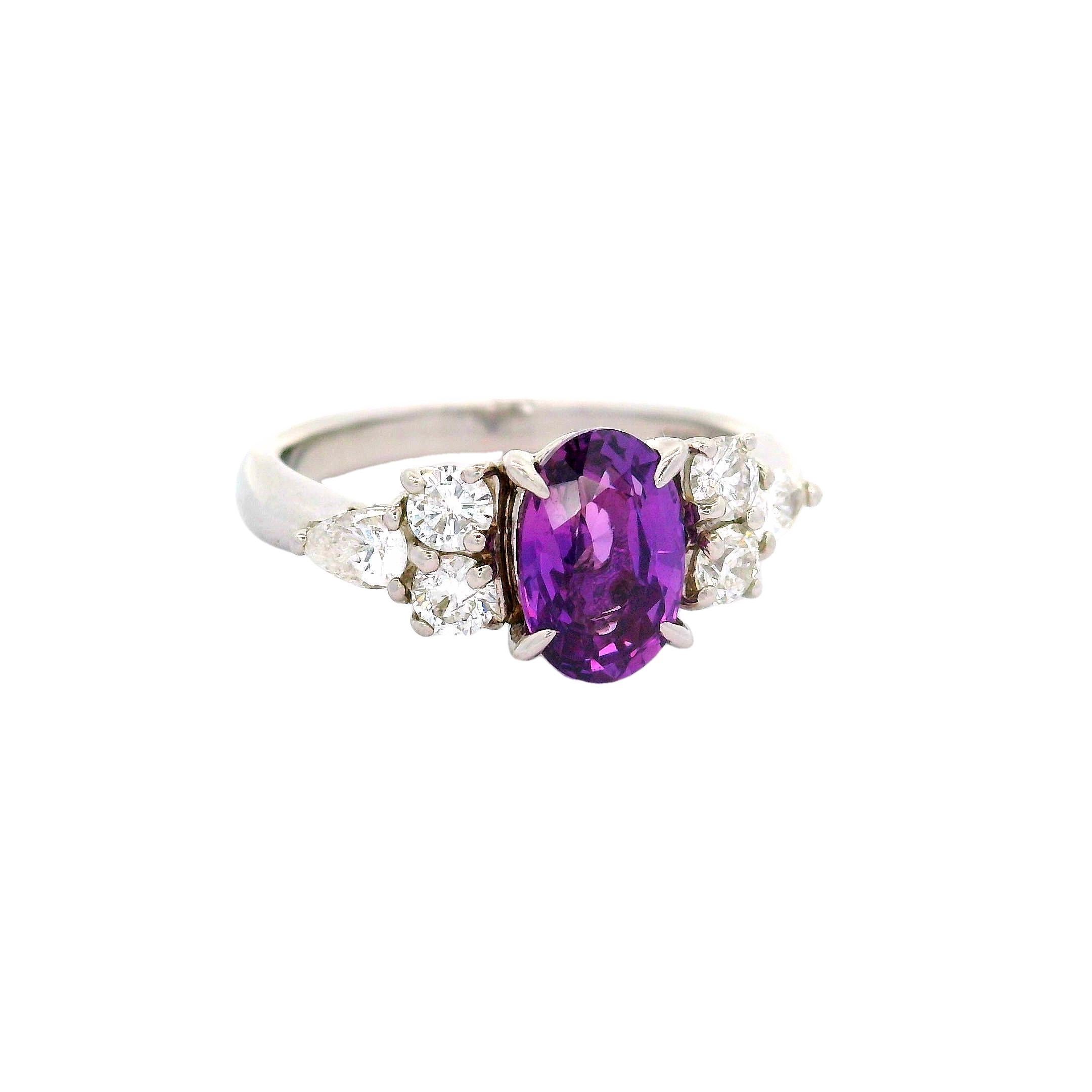 An exquisite natural and unheated color change sapphire, weighing 1.55 carats, is the focal point of this contemporary ring. The sapphire, cut in an oval shape, is a royal purple color in white light and changes to a hot-pink color in yellow night