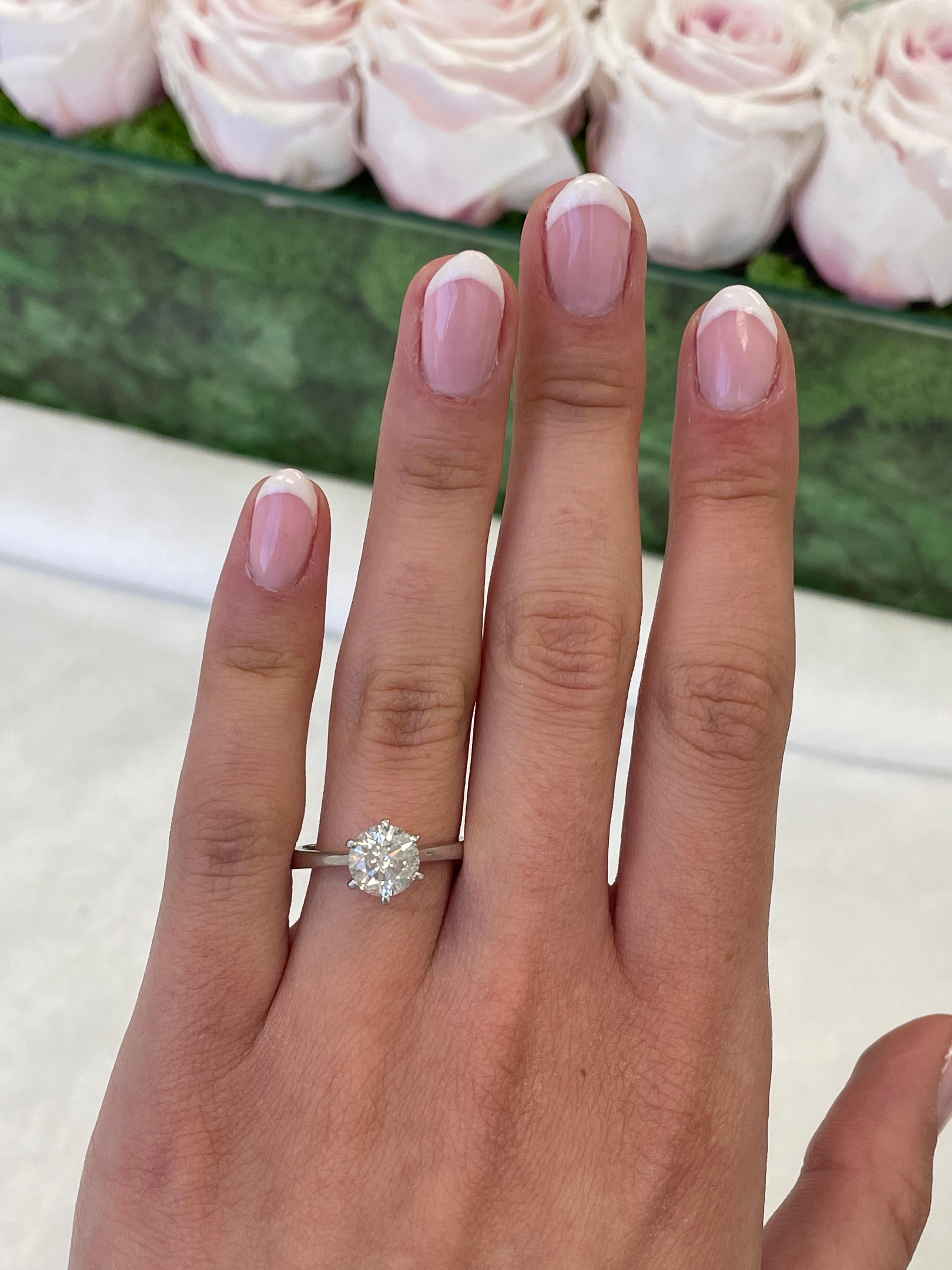 Classic solitaire diamond engagement ring Tiffany style setting.
1.55 carat round brilliant diamond, approximately G color grade and SI2/I1 clarity grade. 18-karat white gold, 3.54 grams, current ring size 7.
Accommodated with an up to date