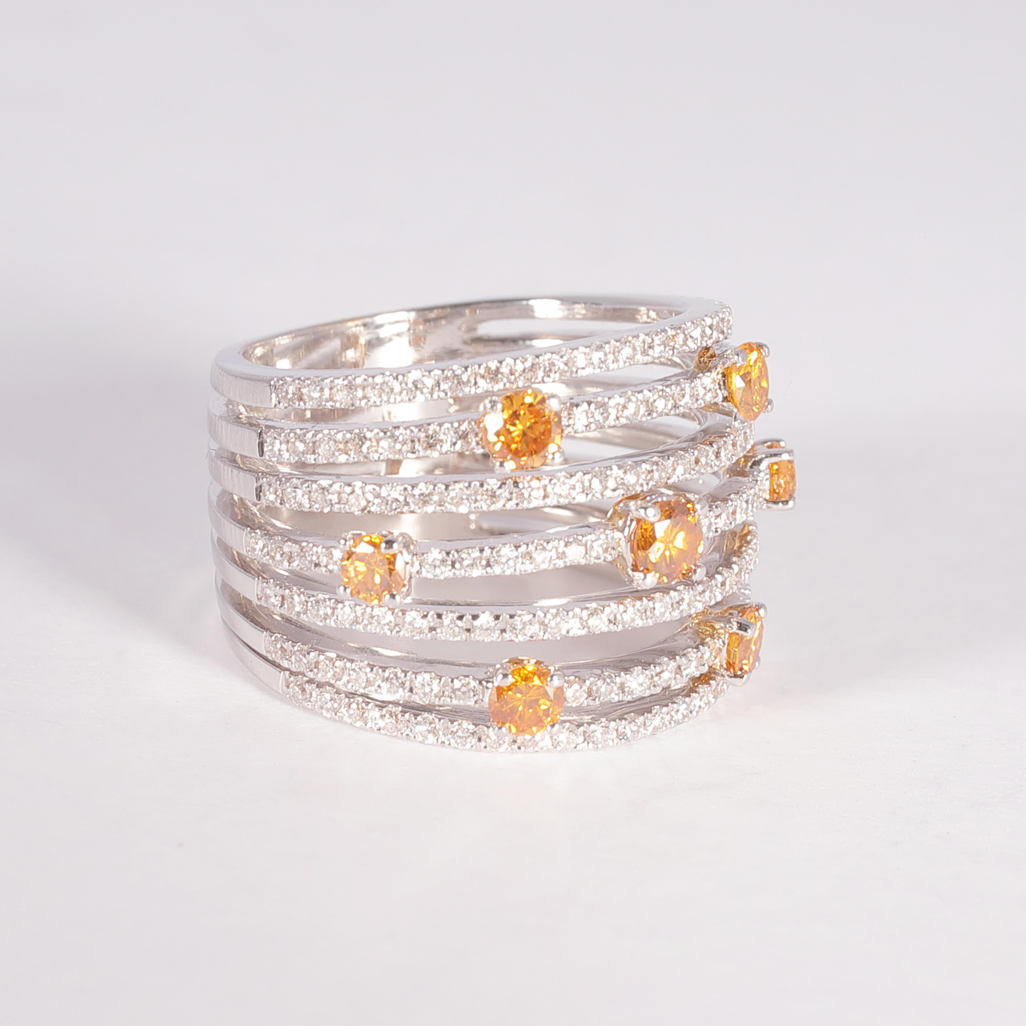 Purchased from famed London jewelry designer David Morris, this beauty features 7 fancy yellow diamonds, alternating on rows with bead-set, white diamonds.  The total stated weight of all of the diamonds is 1.55 carats.  Size 6 3/4. 