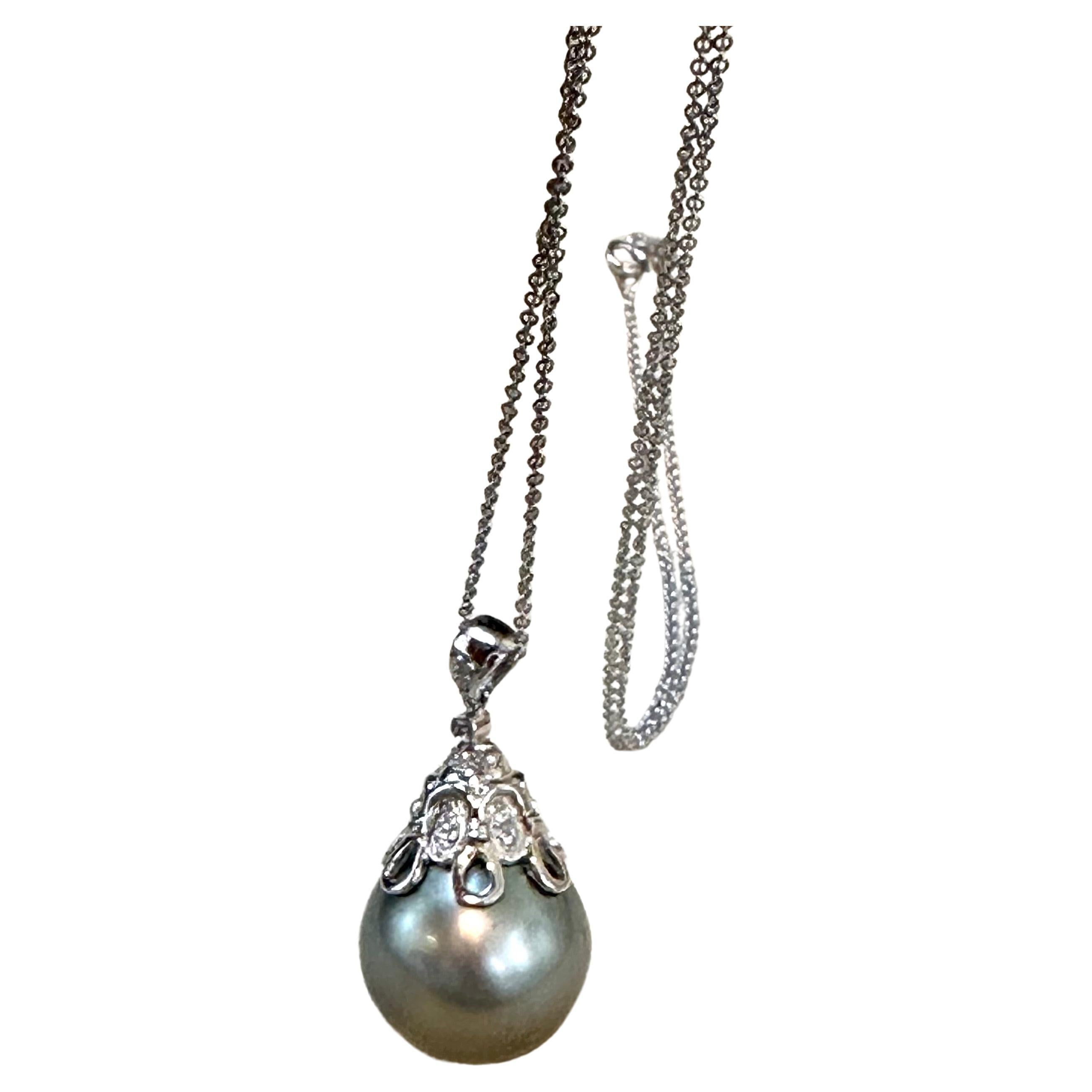 Introducing the exquisite 15.5mm Black Tahitian Pearl & Diamond Pendant in 18K Gold, accompanied by a 14K Gold Chain. This pendant exudes timeless elegance and sophistication.

The centerpiece of this pendant is a stunning 15.5mm Black Tahitian