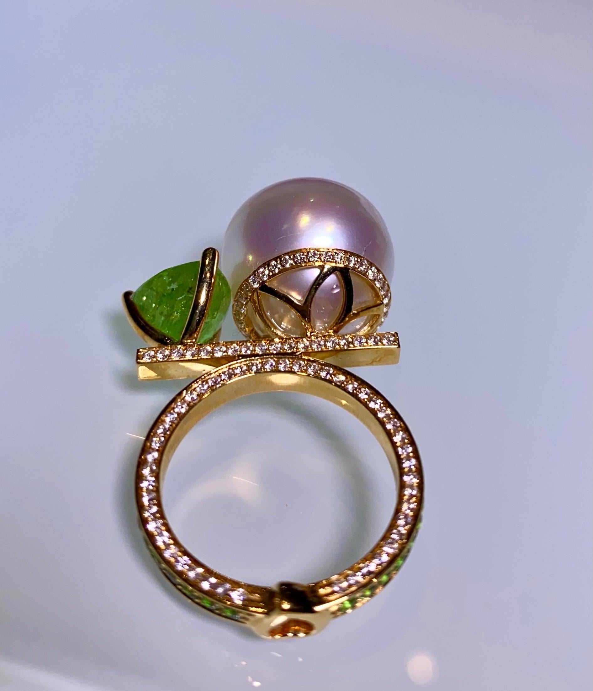 It is a very bold design with pearls and Tsavorite sitting at two ends of a scale. The surface of the ring is full of Diamonds and Tsavorite pave except for the claws. It is a big and unique cocktail ring and would suit those who love a big loud