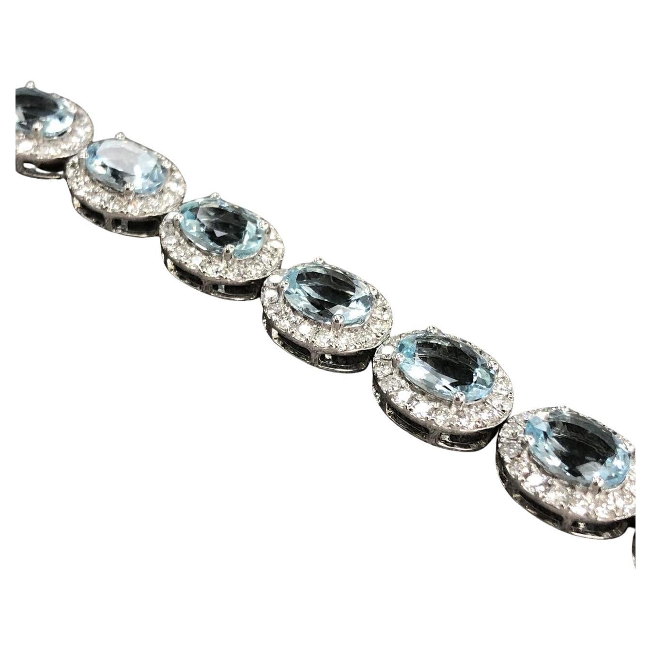 Introducing the epitome of elegance, the 15.58ct Oval Aquamarine and Diamond Halo Bracelet, a dazzling masterpiece in 18kt White Gold. This bracelet features enchanting oval-shaped Aquamarines with a total weight of 12.41ct, radiating a captivating