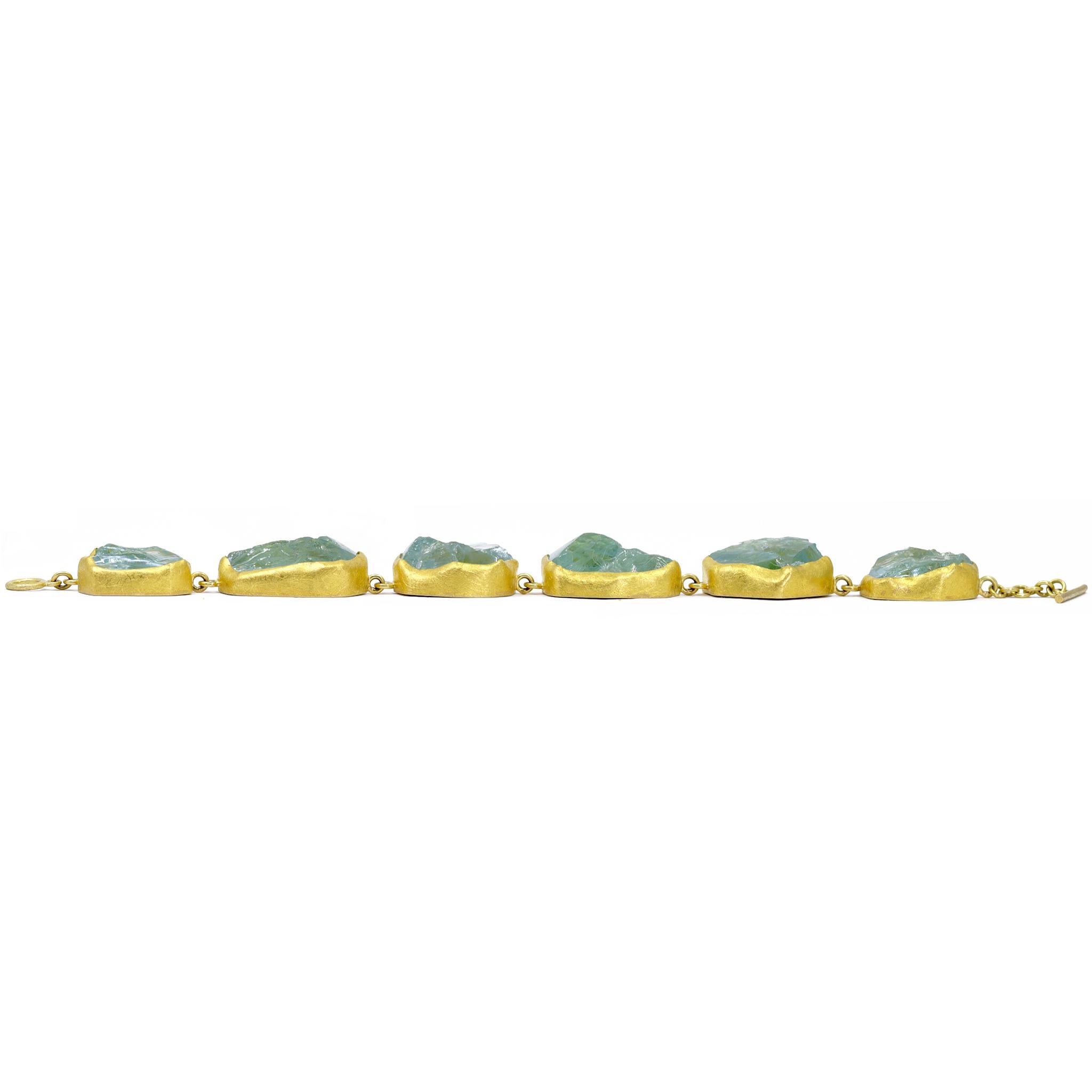 One of a kind bracelet by acclaimed master jewelry maker Petra Class, completely handmade in signature-finished 22k yellow gold and featuring six beautifully matched rough aquamarine crystals totaling 155.20 carats. Each completely natural gem is
