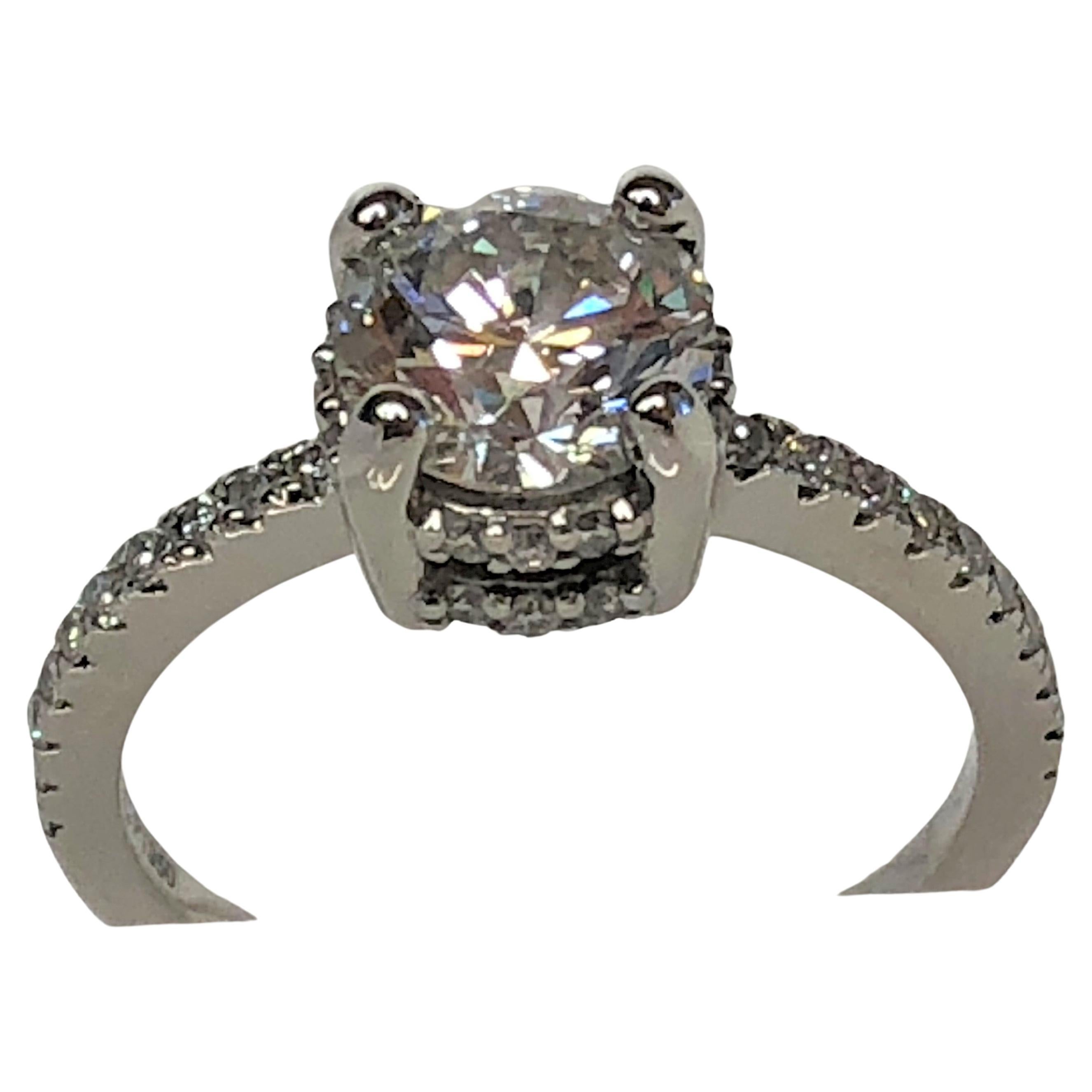 This stone is colorless and shines from every angle.  Adorned with round diamonds down the shoulders and on the bridge, this is an exquisite, quality ring!!
Size 7 platinum mounting.
Center round brilliant cut diamond set with 4 prongs.  1.55ct. 