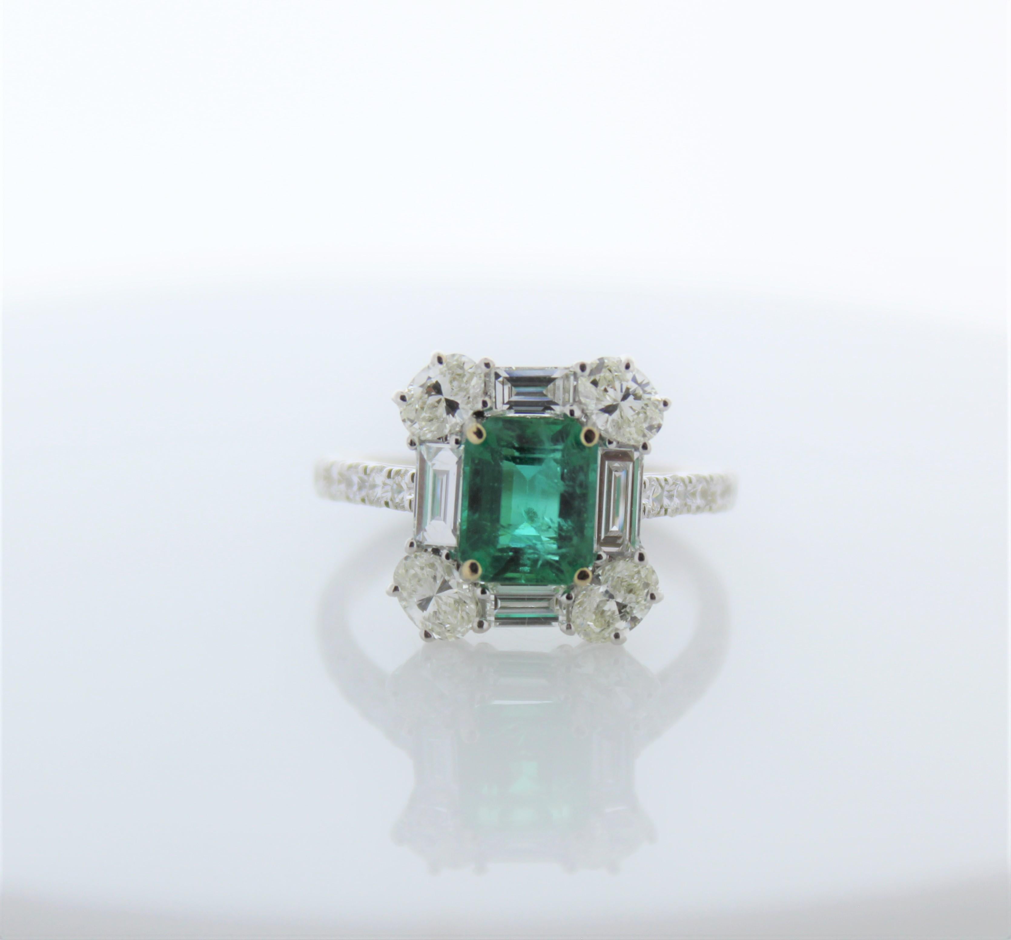 This intricate ring consists of a square green emerald that weighs 1.55 carats. And is surrounded by 20 natural diamonds that total up to 1.63 carats.