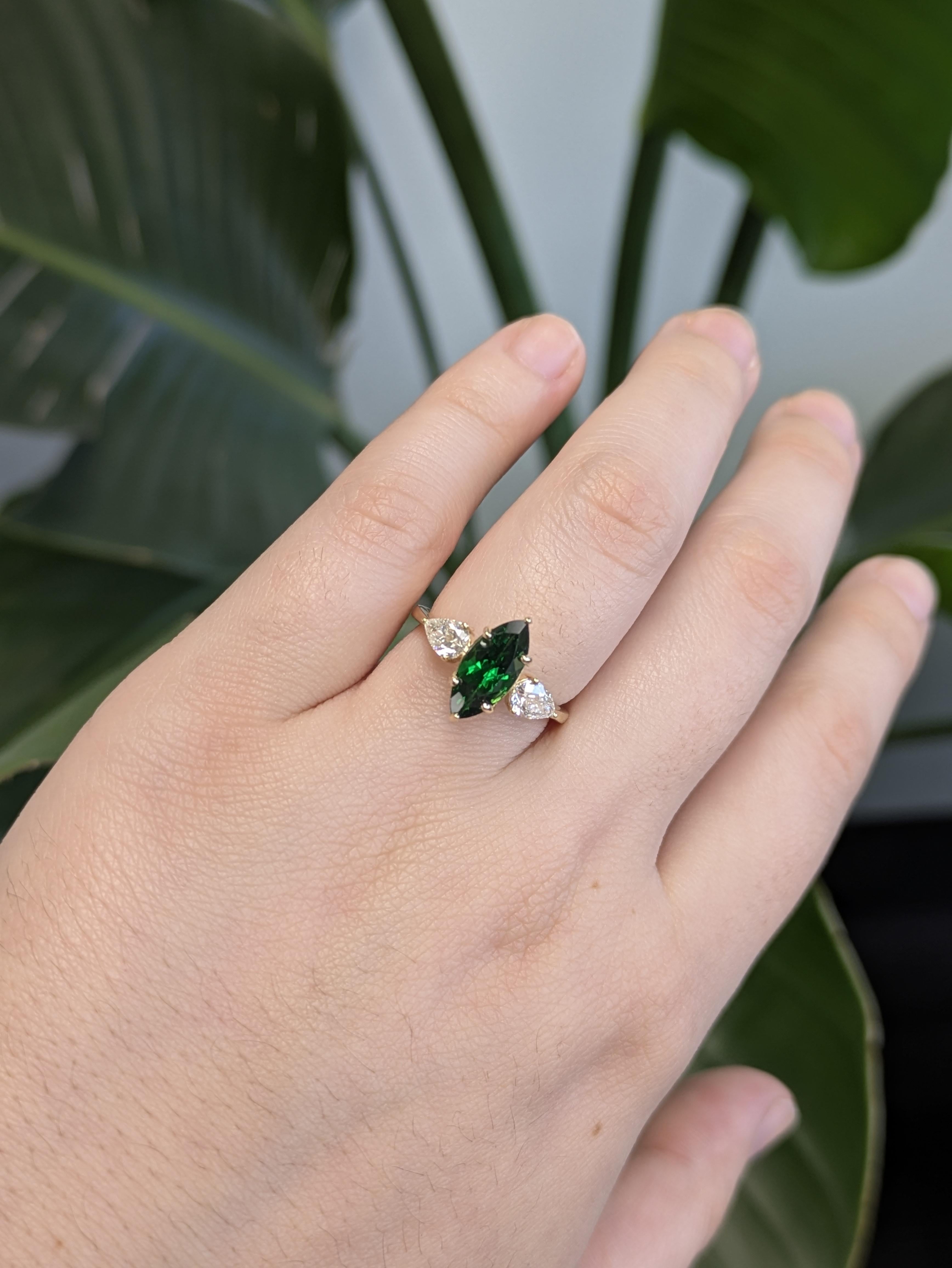 Questo splendido anello mette in mostra una vibrante Tsavorite a forma di marquise, che irradia una ricca brillantezza verde al suo centro. Con diamanti naturali a forma di pera, il design è incastonato in un lussuoso oro giallo massiccio 14 carati,