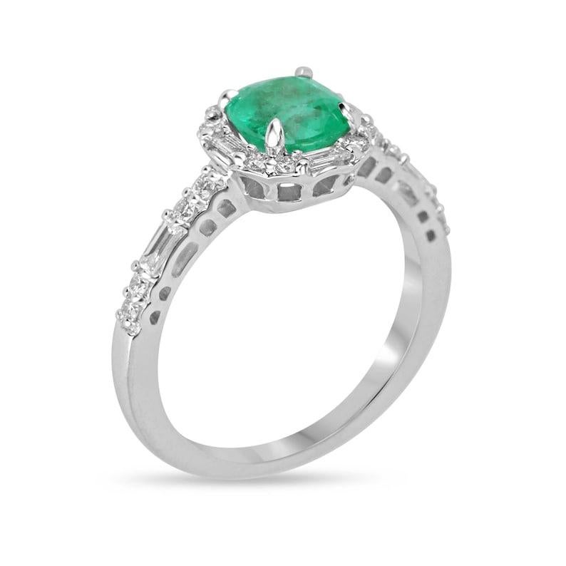 Introducing our enchanting emerald and diamond engagement ring, showcasing a captivating 1.20-carat natural cushion cut Colombian emerald with a medium vivid green color, exuding radiance and transparency in its quality. Set in a delicate four-prong