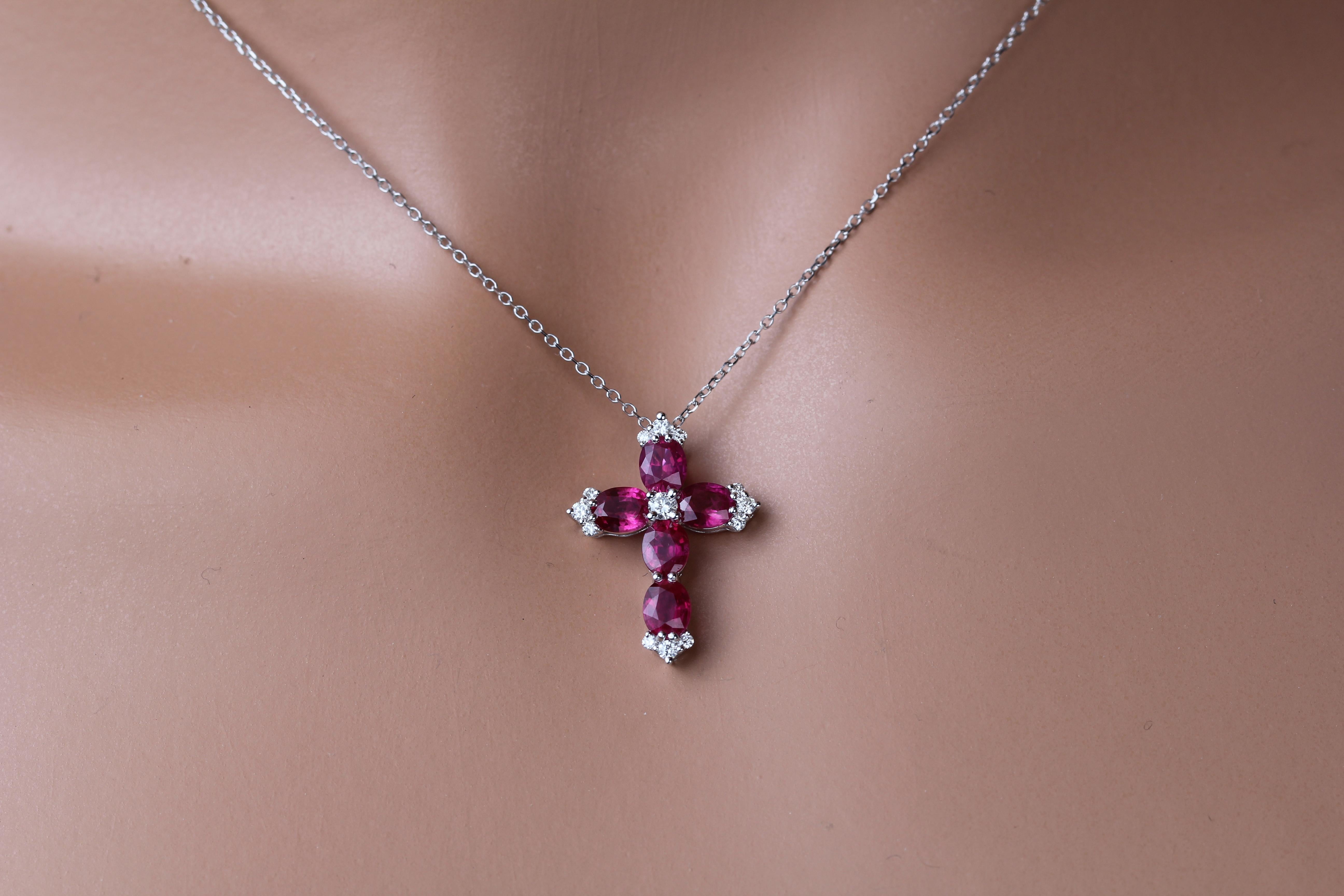 This stunning cross pendant features five oval cut vivid red rubies (total weight 1.56 carats), around a central round diamond. Additional trios of round diamonds decorate the four points of the cross. The total diamond weight is 0.15 carats.

Set