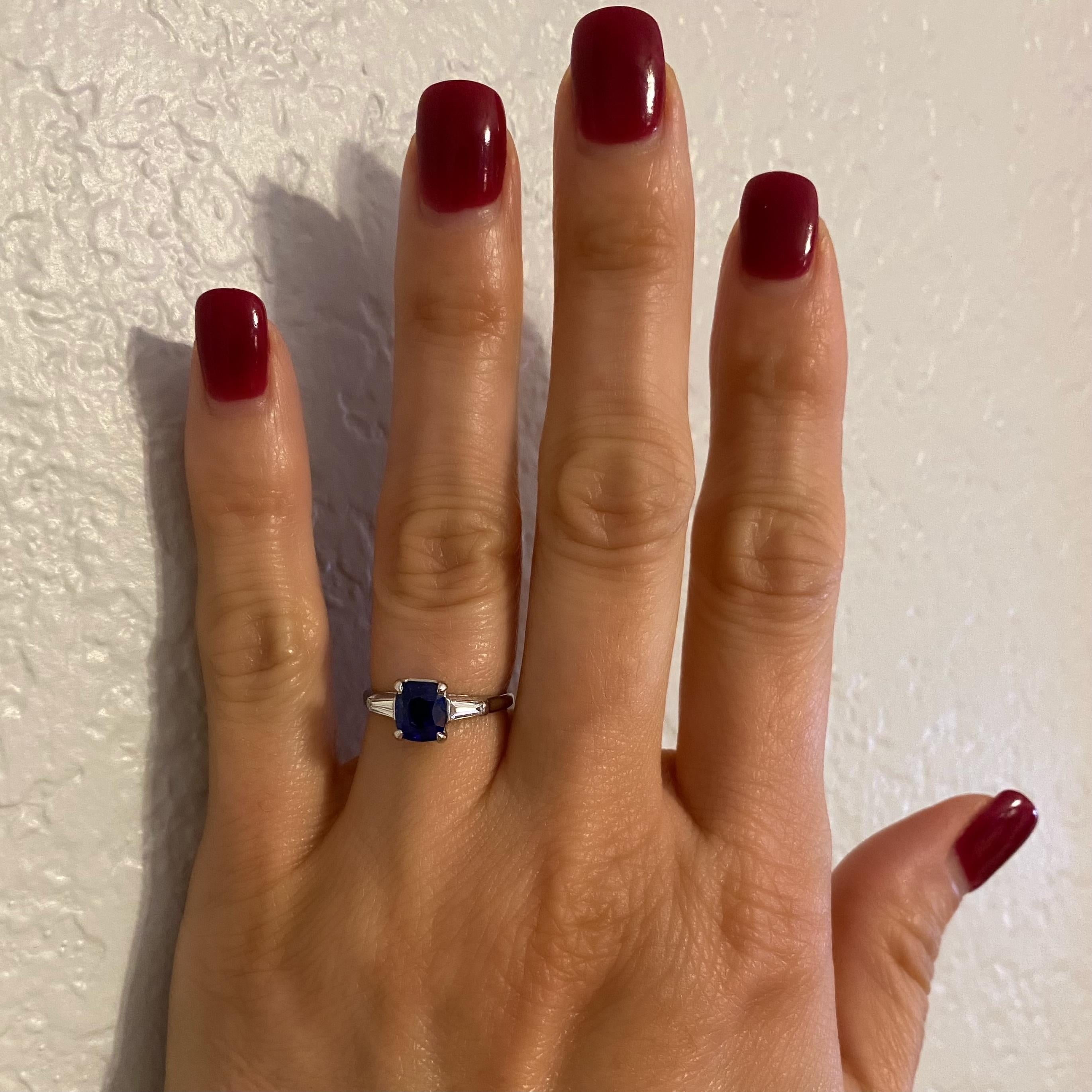 Beautiful and finely detailed Cocktail Ring center set with a securely nestled 1.56 Carat Cushion-cut NO HEAT Kashmir Natural Blue Sapphire; either side set with tapered baguette Diamonds, approx. 0.40 total carat weight, F color, VS1 clarity.