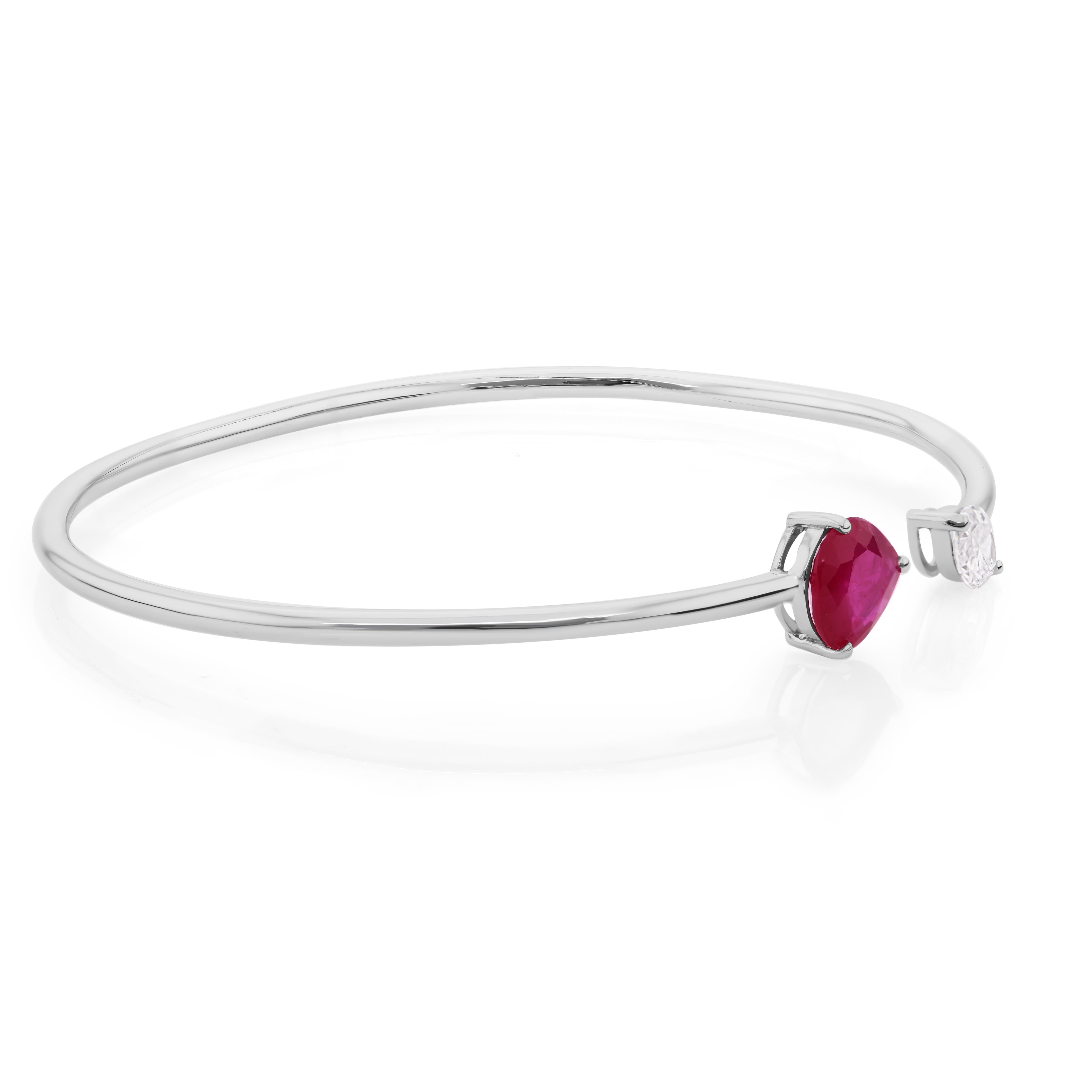 Cet élégant bracelet manchette présente un rubis en forme de poire de 1,56 carat complété par 0,42 carat de diamants, le tout serti dans de l'or blanc 18 carats. L'association d'un rubis vibrant et de diamants étincelants crée un contraste