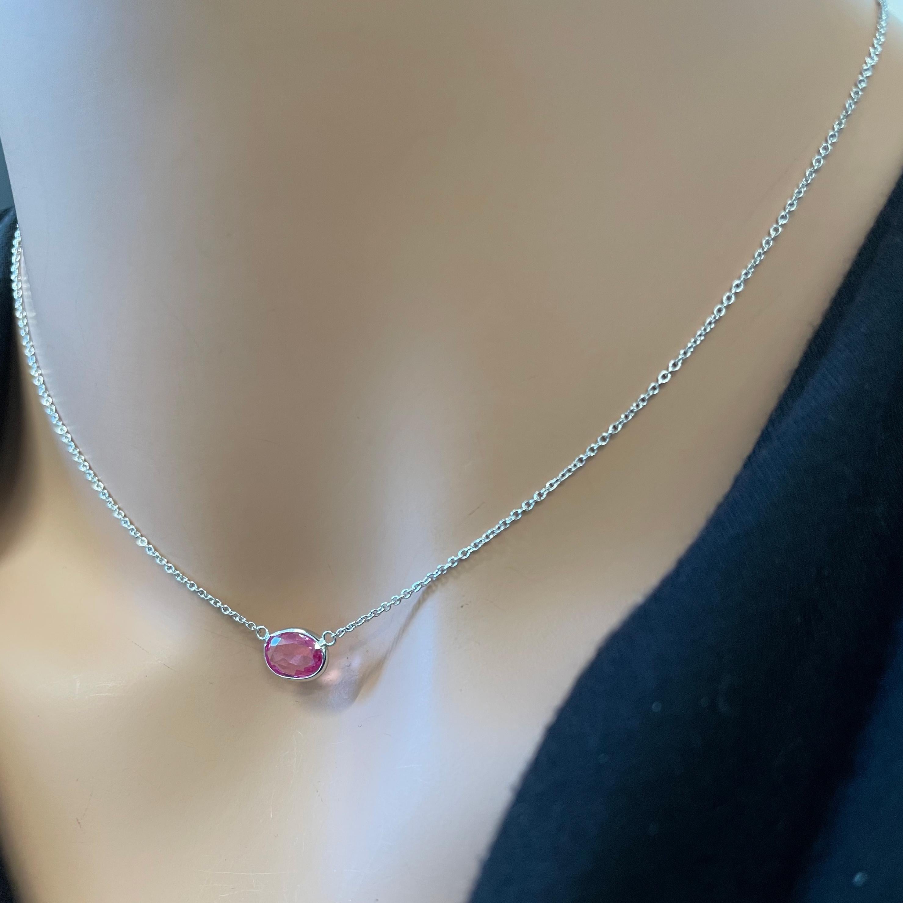 The 1.56 carat Oval Cut Pink Padparadscha Necklace in 14K White Gold is a truly enchanting piece of jewelry that seamlessly marries sophistication with a touch of romance. This necklace showcases a captivating Padparadscha sapphire, revered for its