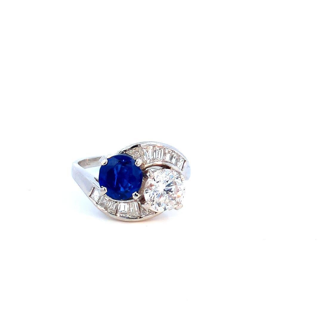Introducing our Sapphire and Diamond 2 Stone Ring, a symbol of enduring love and timeless elegance. This exquisite piece features a heated blue sapphire weighing 1.56 carats and a round brilliant diamond weighing 1.30 carats, both set in platinum