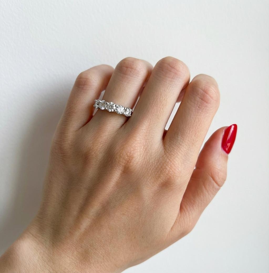 Ein raffinierter 5-Stein-Ehering aus 14-karätigem Weißgold, besetzt mit ca. 1,56 Karat natürlichen, runden Diamanten im Brillantschliff. 
Die gleichmäßig verteilten Steine sorgen für eine ausgewogene Brillanz, und das klare Profil des Rings eignet