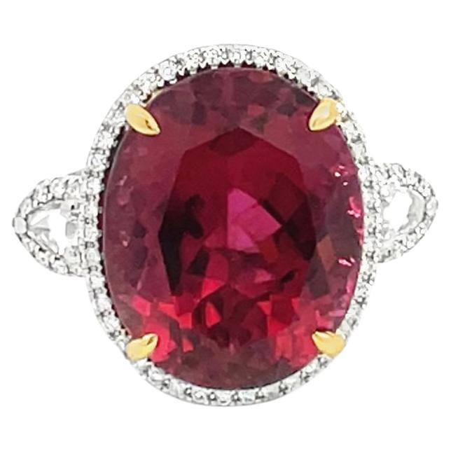 This stunning cocktail ring showcases a large 15.65 Carat Oval Rubellite Tourmaline with a Diamond Halo. The Rubellite is flanked by two Rose Cut White Diamonds.

This ring is set in 18k White Gold, with 18k Yellow Gold prongs on the center stone.