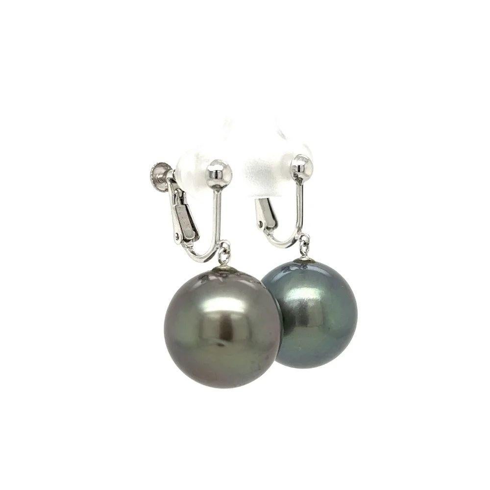 Simply Beautiful! Finely detailed Tahitian South Sea Pearl Gold Drop Earrings. Each earring Hand set with a 15.65mm Tahitian South Sea Pearl. Hand crafted 14K White Gold Clip back mounting. More Beautiful in real time! A piece you’ll turn to time
