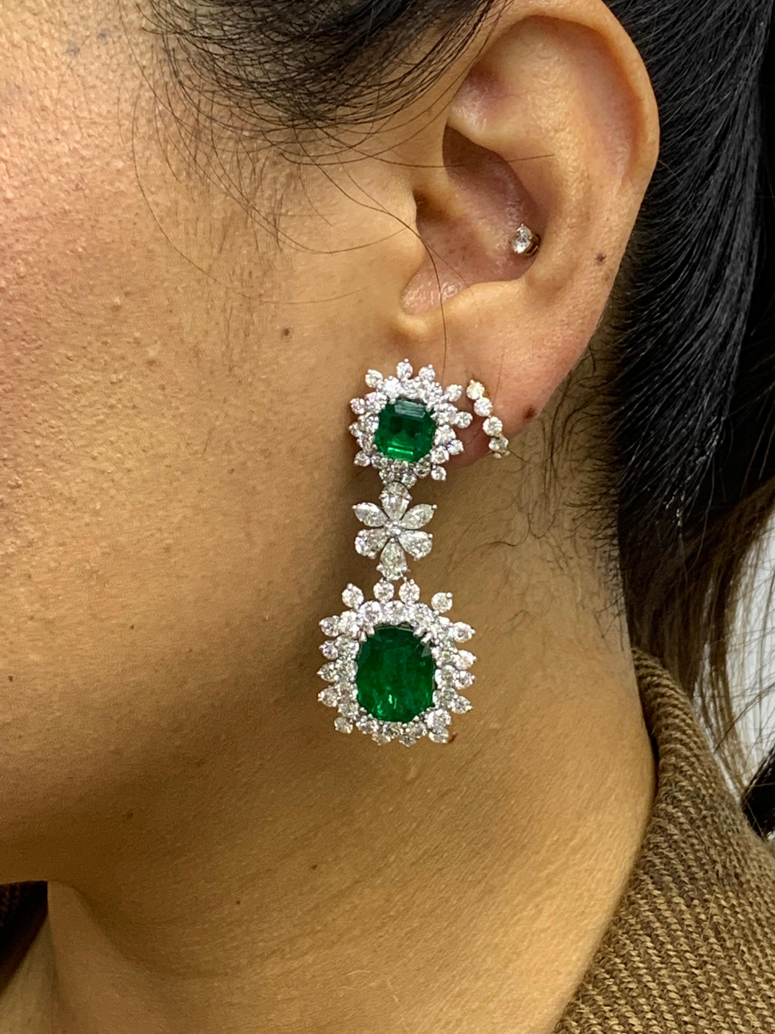 Burst out in style with this gorgeous pair of 18k white gold earrings. Showcases 4 fancy emerald cut emeralds weighing 15.67 carats surrounded by sparkling round diamonds in a creative floral motif. Suspended on vibrant radiant cut emeralds