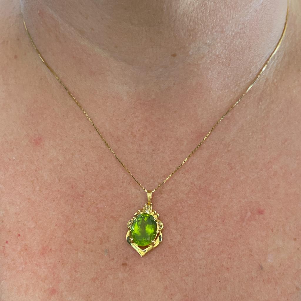 This wonderful vintage pendant presents a large oval peridot in a rich 18 karat gold crest-shaped frame with diamond accents. Peridot is the August birthstone. Mark a graduation, anniversary, or important milestone! This pendant would be perfect as