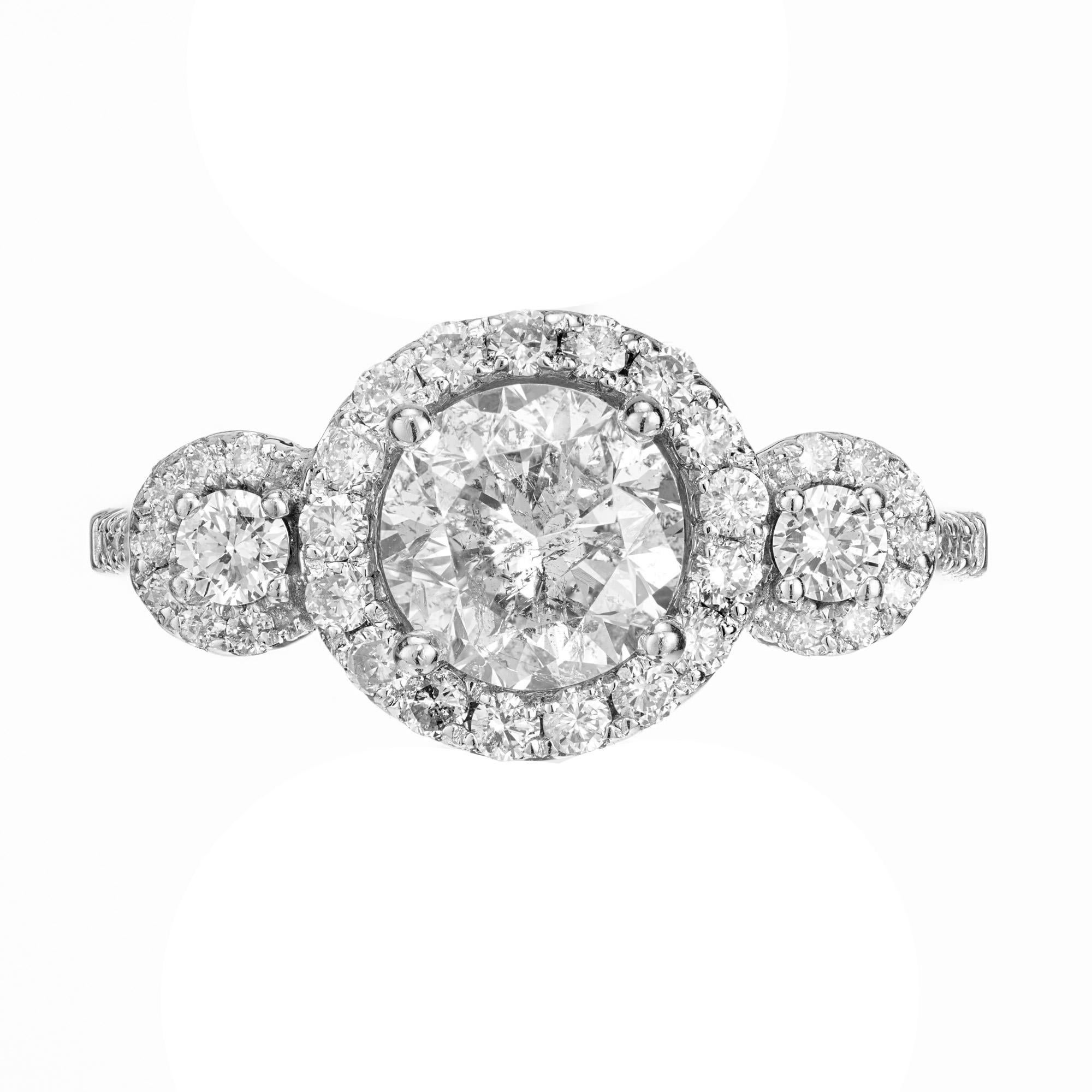 3 stone Halo design diamond engagement ring. EGL certified 1.57ct round center diamond set in a 14k white gold mounting, accented with 2 round cut side diamonds. Each stone has a halo of round cut diamonds, Each shoulder is enriched with 8 diamonds