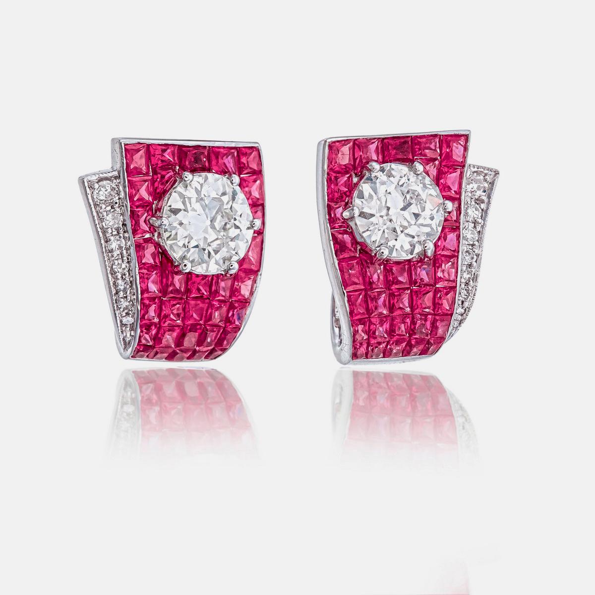 These Art Deco-inspired earrings by Rewa Jewels feature 4.88 carats of hand-cut rubies, set using an invisible setting, and 1.69 carats of diamonds. The diamonds include two round old-cut stones weighing 1.57 carats, with an additional 0.12 carat in