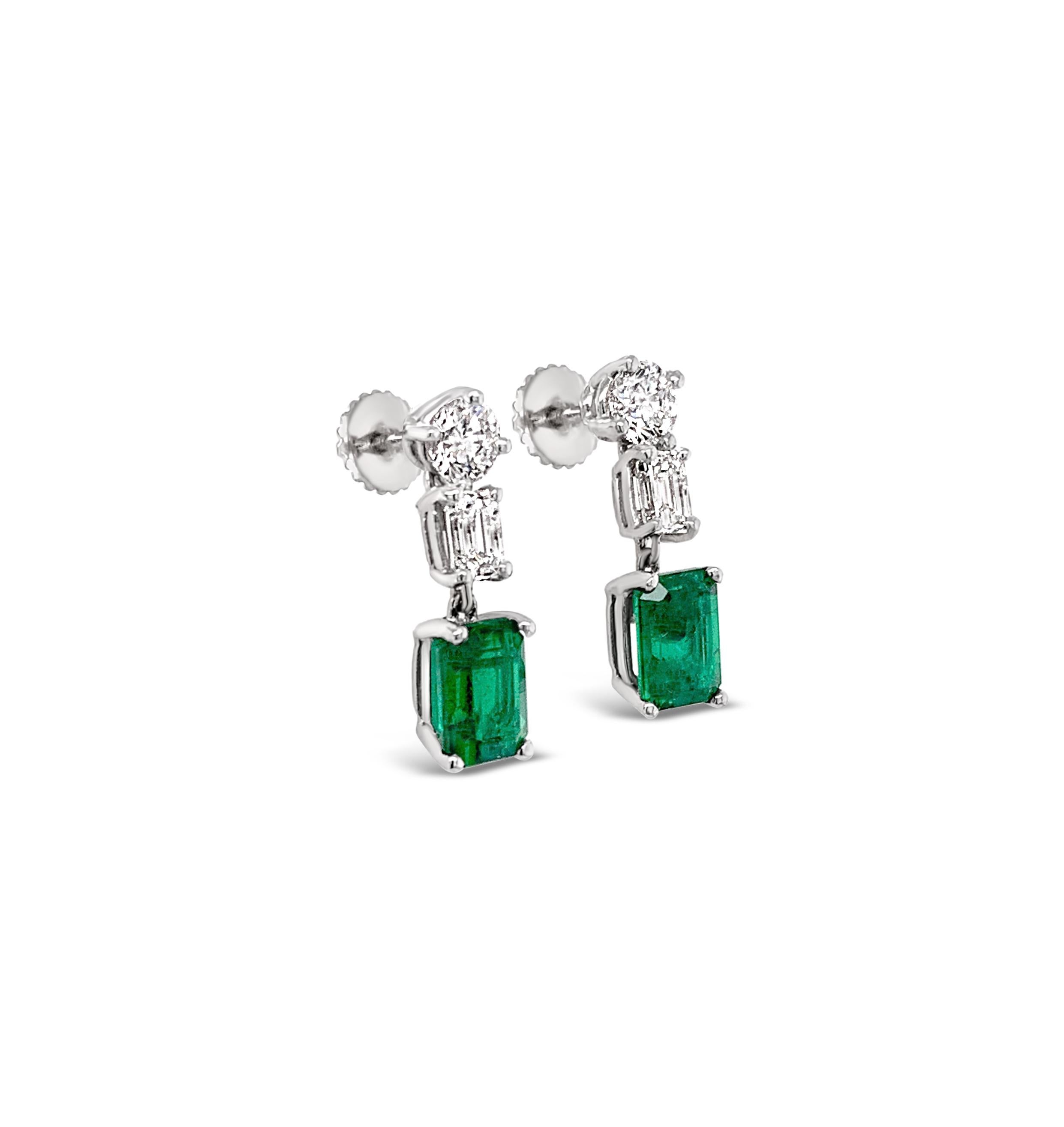 Emerald and Diamond Earrings in Platinum.  Emerald-cut emeralds weigh 1.57 Carat (total weight).  Round brilliant cut and emerald-cut diamonds weigh 0.97 Carat (total weight).  Diamond color grade is G-H and clarity range is VS-VS2.  The earrings
