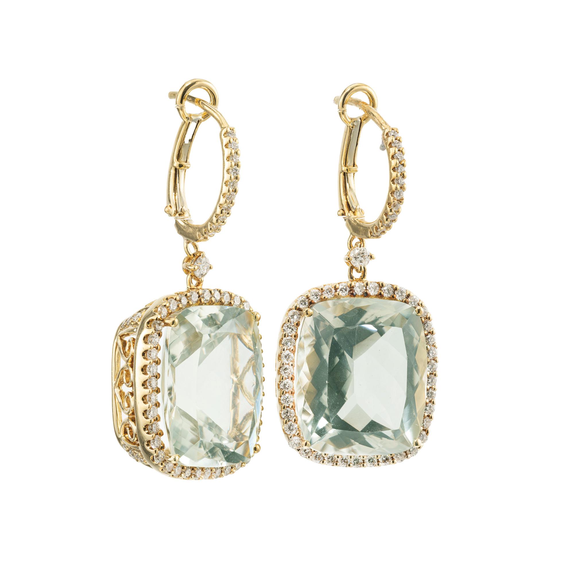 Quartz and diamond halo dangle earrings. At the center of these exquisite earrings are two beautiful rare lightly colored and slightly bluish green cushion shape quartz with a total carat weight of 15.70cts. Each quartz is adorned with a halo of