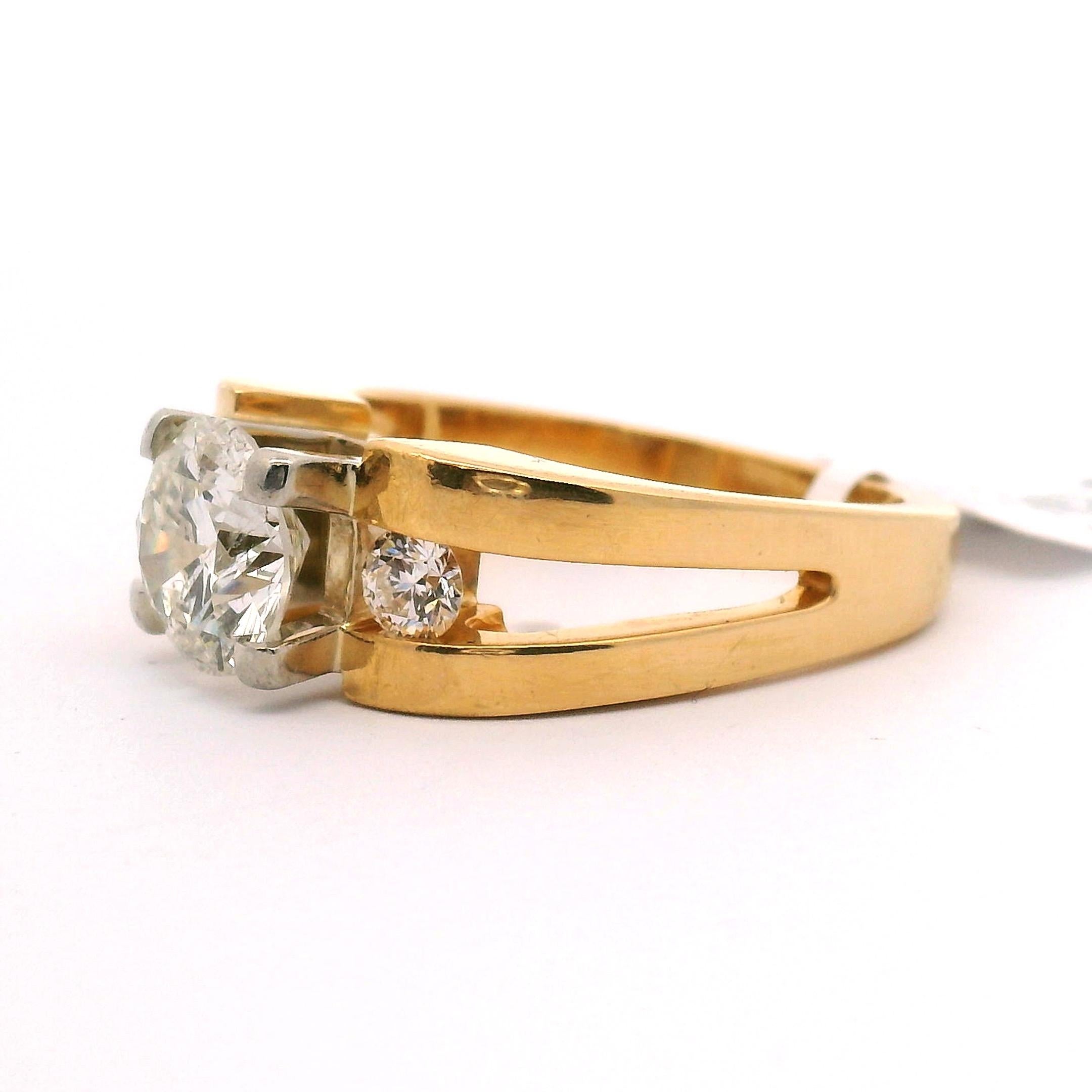 Anello di fidanzamento in stile deco della fine del XX secolo con cinturino in oro giallo. Con diamante centrale a taglio brillante e 1 diamante a taglio brillante su ciascun lato:

1,57ct. Taglio rotondo brillante 
Chiarezza SI2 Colore G-H.

2