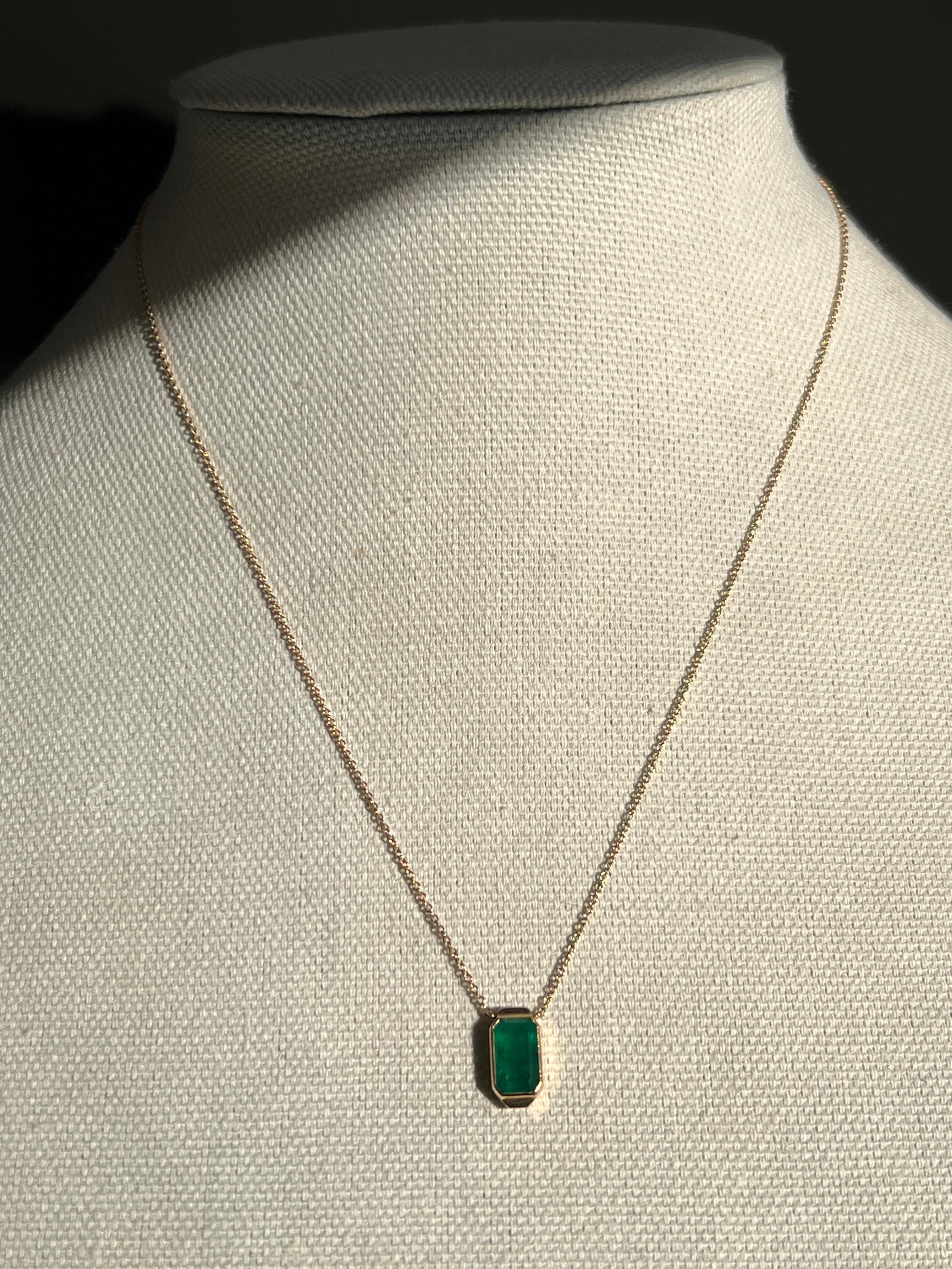 Un collier pendentif Art déco présentant une lumineuse émeraude de 1,58 carat, mesurant 9,33 x 5,97 mm, élégamment sertie d'un chaton en or jaune 14k. Conçue à l'origine comme une lorgnette délicate, cette pièce a été réimaginée avec soin en un