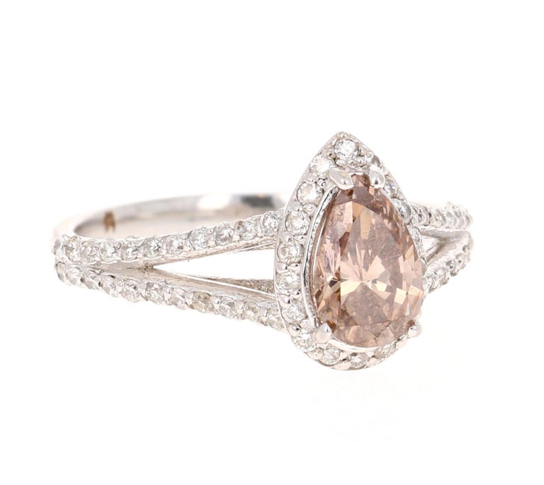 This ring has a Natural Pear Cut Brown/Champagne Diamond that weighs 1.08 Carats and is surrounded by 62 Round Cut Diamonds that weigh 0.50 Carats. The Pear Cut Diamond measures at 6 mm x 8 mm (Width x Length) and the face of the ring measures at