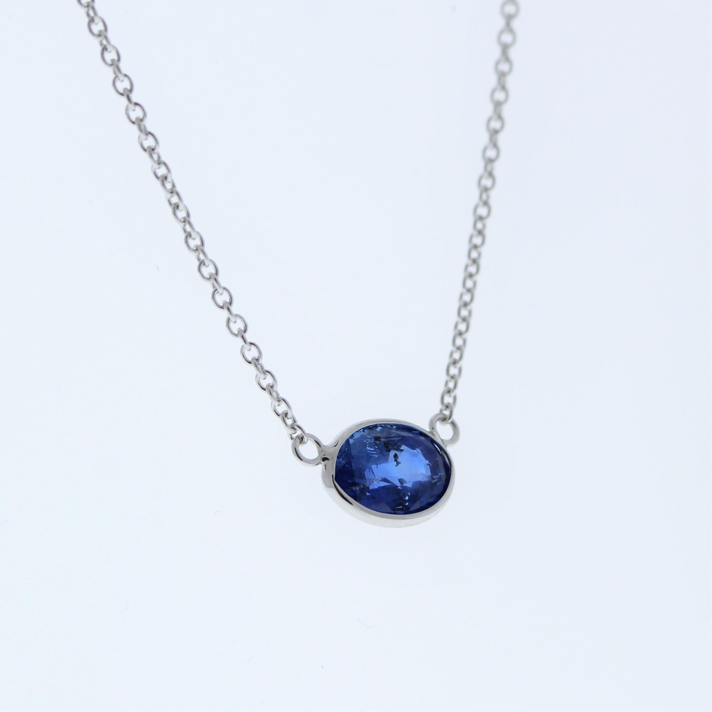 The necklace features a 1.58-carat oval-cut blue sapphire set in a 14 karat white gold pendant or setting. The oval cut and the blue sapphire's color against the white gold setting are likely to create an elegant and versatile fashion piece,