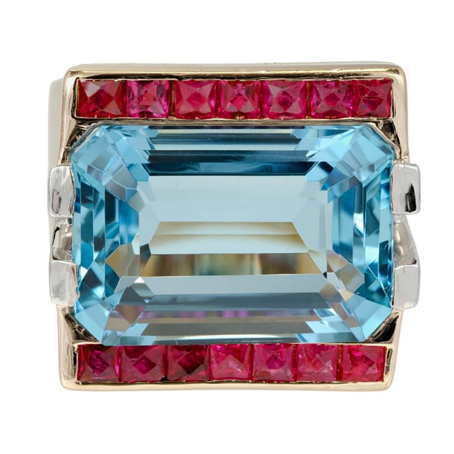 Retro Art Deco 1935 natural untreated Aqua, ruby and diamond cocktail ring. At the center of this 14k yellow gold ring is a stunning 15.83 Carat Natural emerald cut Aquamarine, framed by two rows of vibrant calibre cut rubies which are accented by