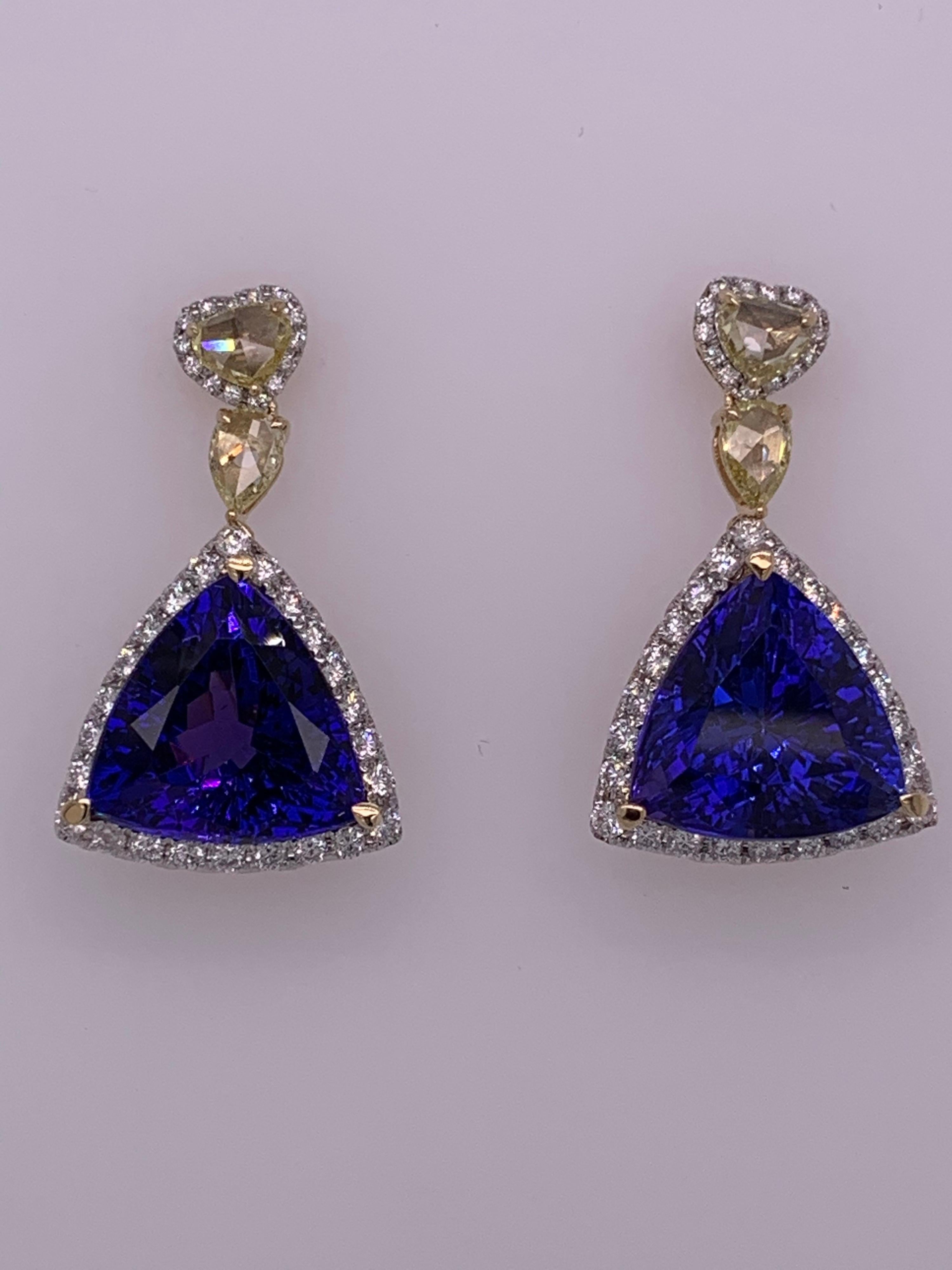  Trillion shaped Tanzanite surrounded by white diamond with yellow diamond on upper portion of earrings set in yellow gold. Beautiful piece with fine craftsmanship and brilliant color tanzanite.
Tanzanite: 15.83 ct
White Diamond: 1.01 ct
Yellow