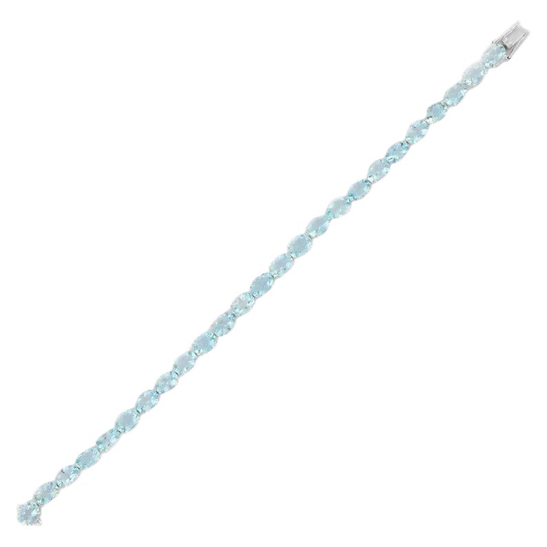 This Aquamarine Tennis Bracelet in 18K gold showcases 25 endlessly sparkling natural aquamarine, weighing 15.83 carats. It measures 7.25 inches long in length. 
Aquamarine is useful for moving through transition and change. 
Designed with perfect