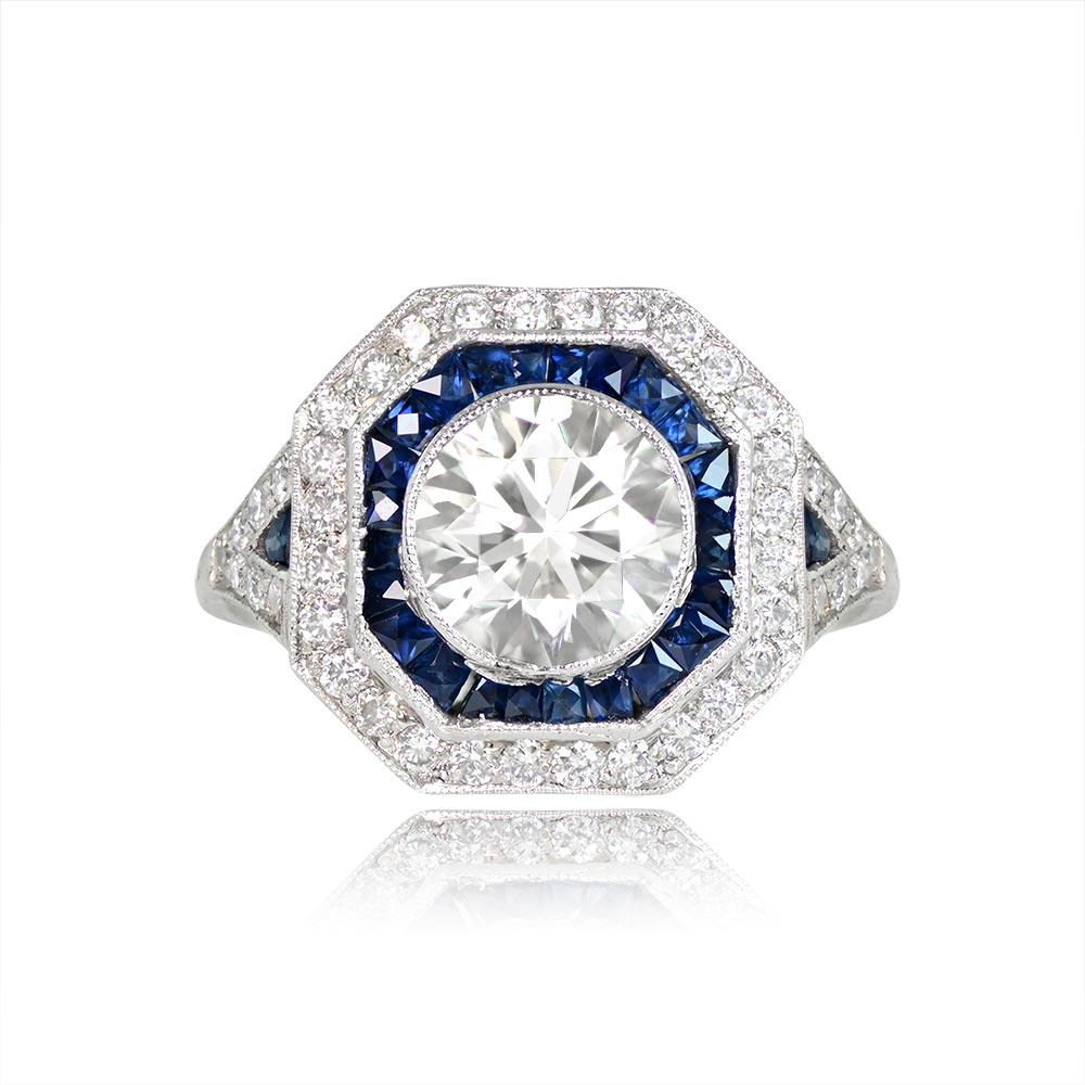 A captivating engagement ring boasting a beautiful 1920s-old European cut diamond, approximately 1.58 carats, with J color and VS1 clarity. The center diamond is elegantly complemented by a geometric double halo of sapphires and diamonds. This