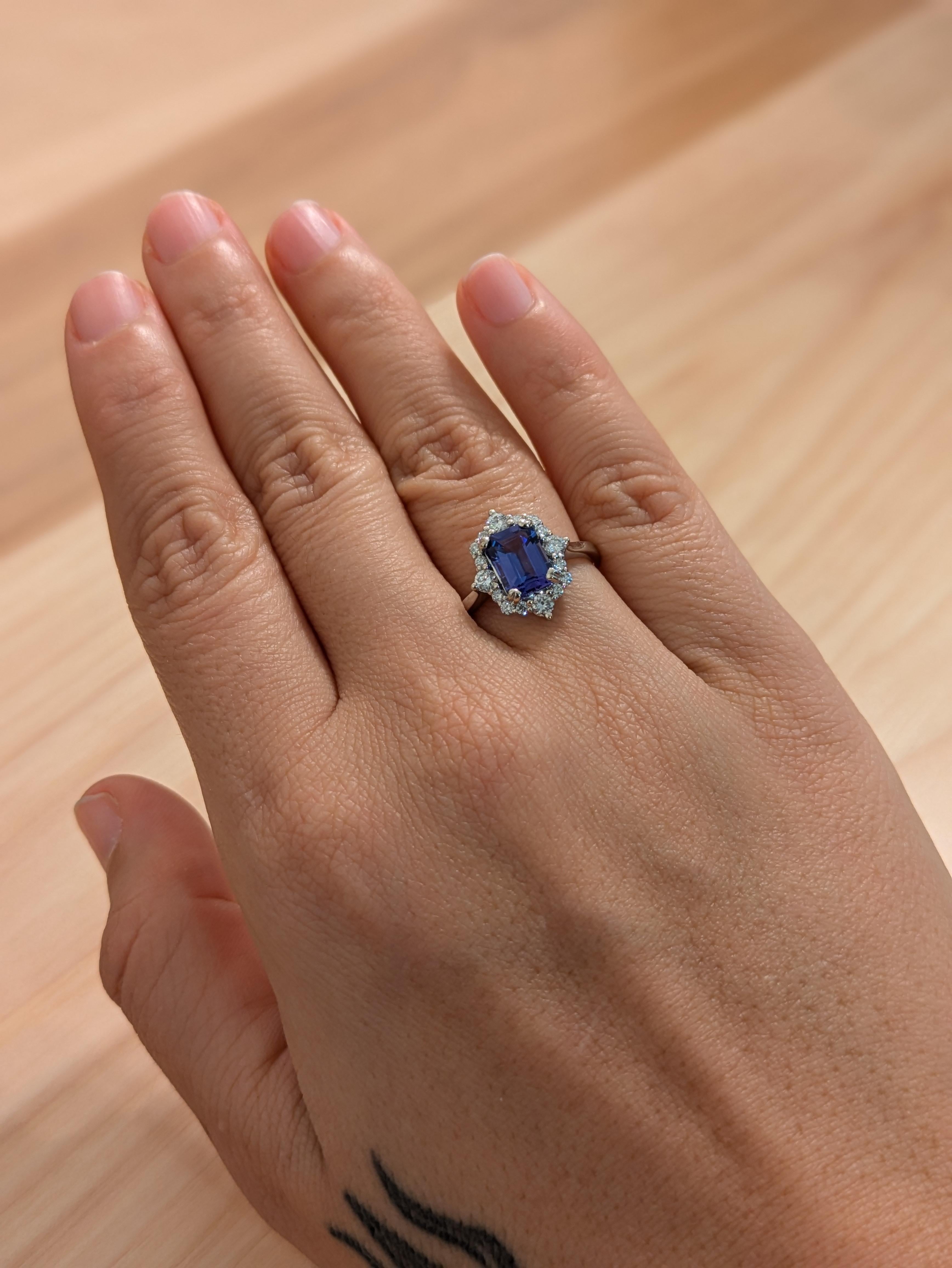 Cette magnifique bague est ornée d'une tanzanite de taille émeraude, connue pour sa riche couleur bleu-violet. Les diamants qui entourent la tanzanite lui confèrent un éclat supplémentaire, ce qui en fait un bijou luxueux et élégant. La monture en