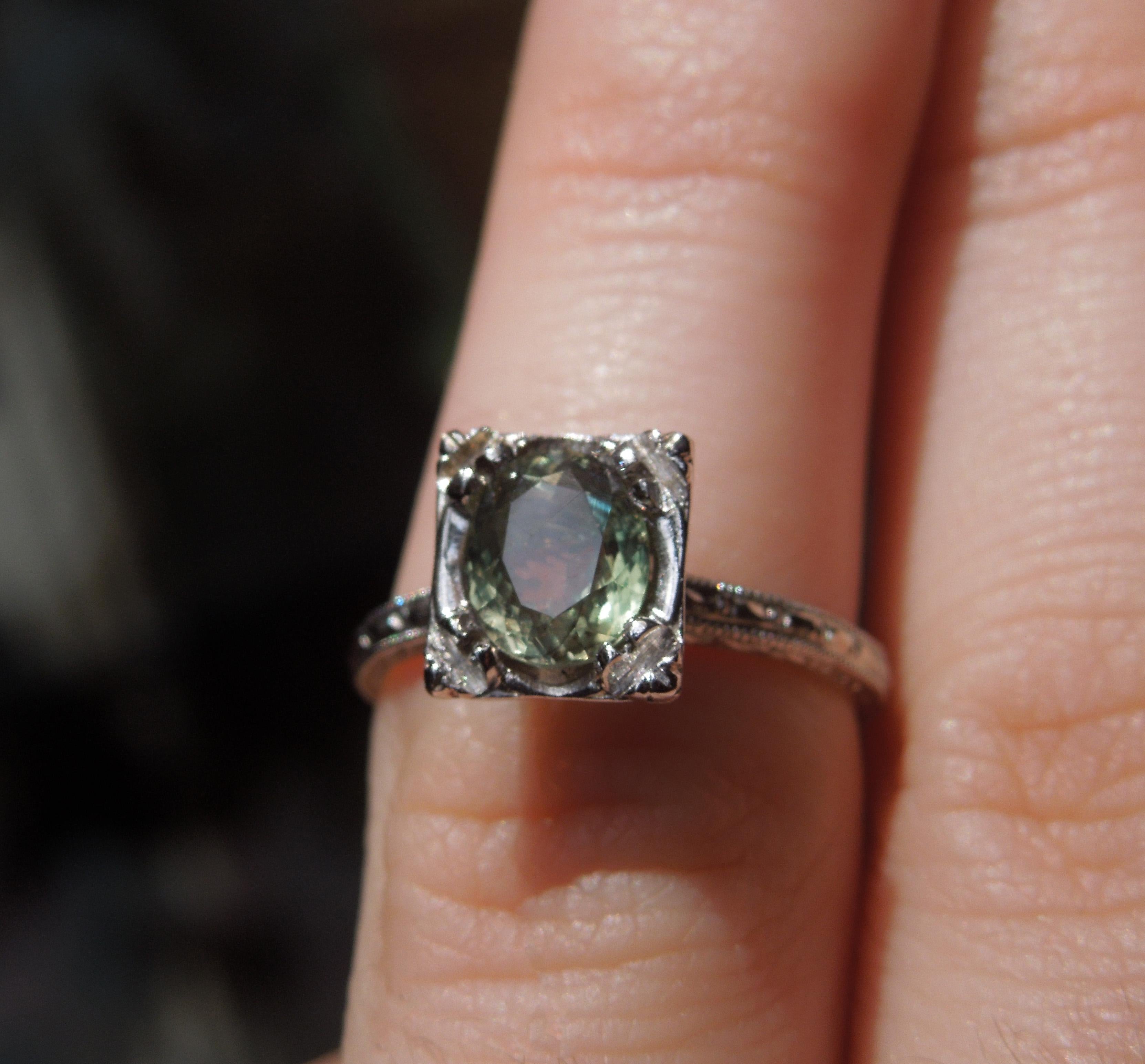 This Alexandrite Square Solitaire Ring features a 1.59 carat GIA Certified Natural Color Changing Oval cut Alexandrite with an excellent color change as far as the spectrum from green to purple, as stated in the GIA lab report. This metamorphosis is