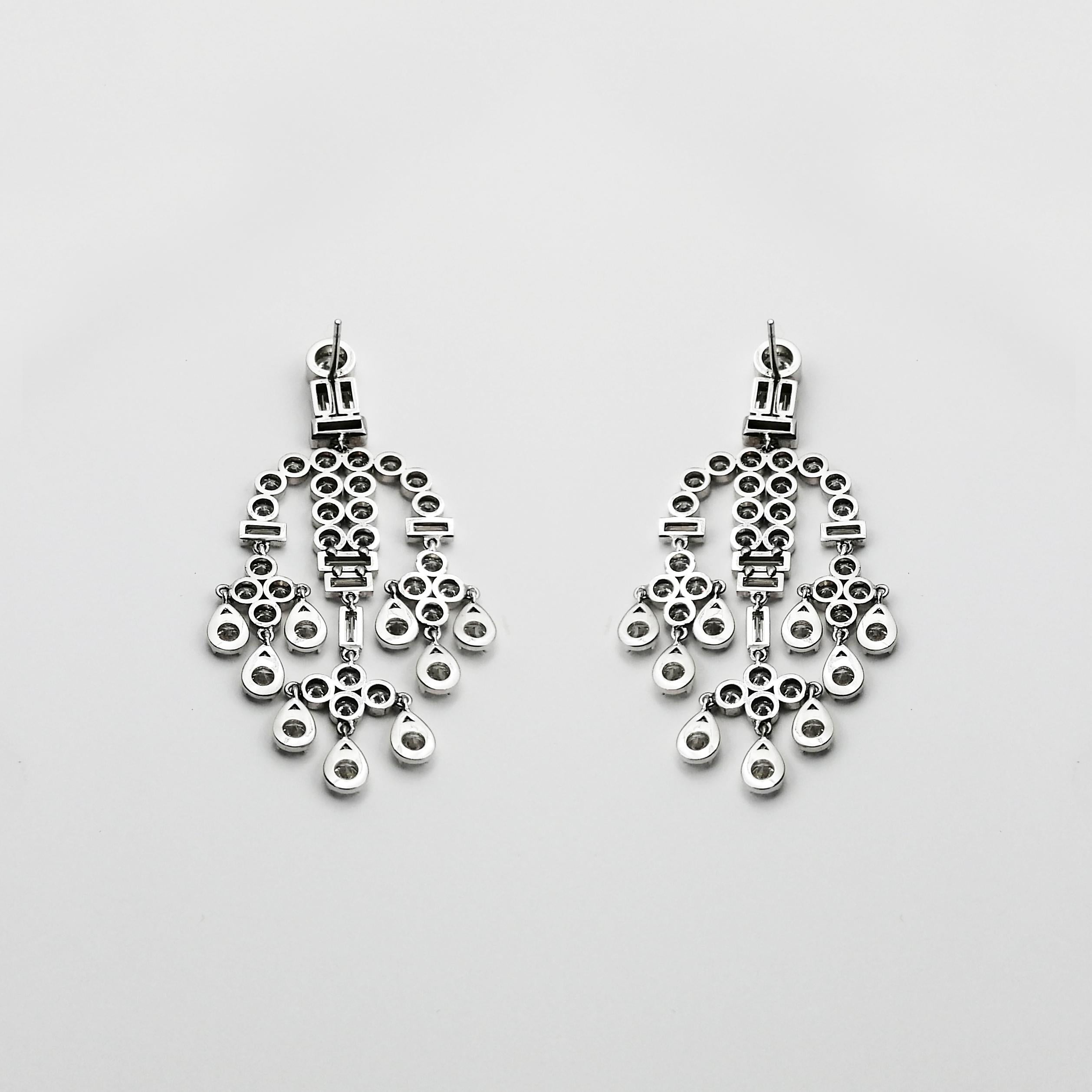 A precious arrangement of brilliant and baguette-cut diamonds, these timelessly elegant yet imposing earrings bring Art Déco design to its utmost glamorous form. The delicate structure is crafted from 18 carat white gold embraces 15.9 carats of