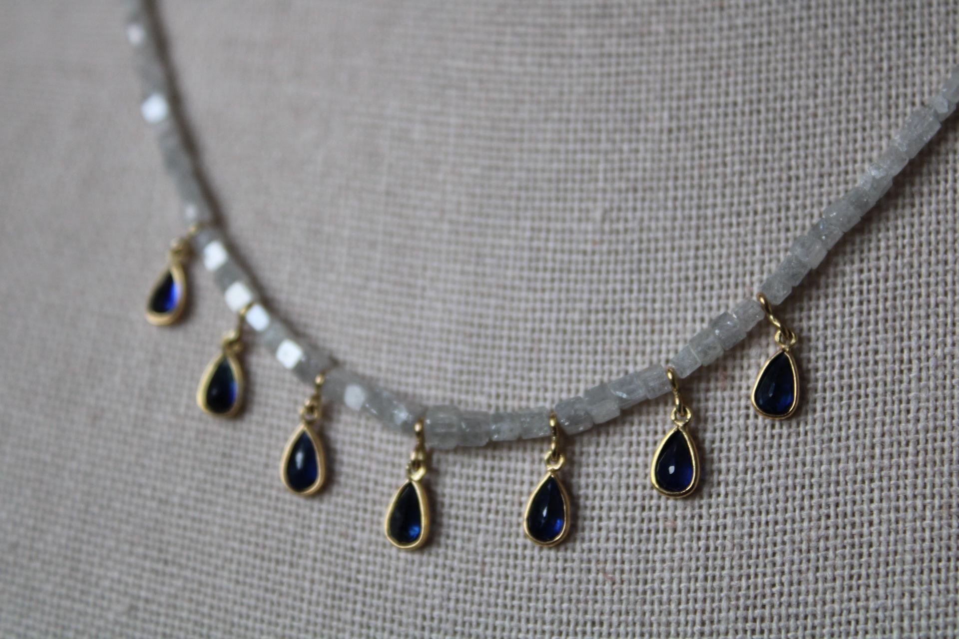This gorgeous diamond bead necklace is comprised of 15.99 carats. It has seven deep blue sapphire pear pendants set in 18K gold bezel. The diamond beads are cut in tube shape which allow for maximum sparkle and shine. The necklace measures 18