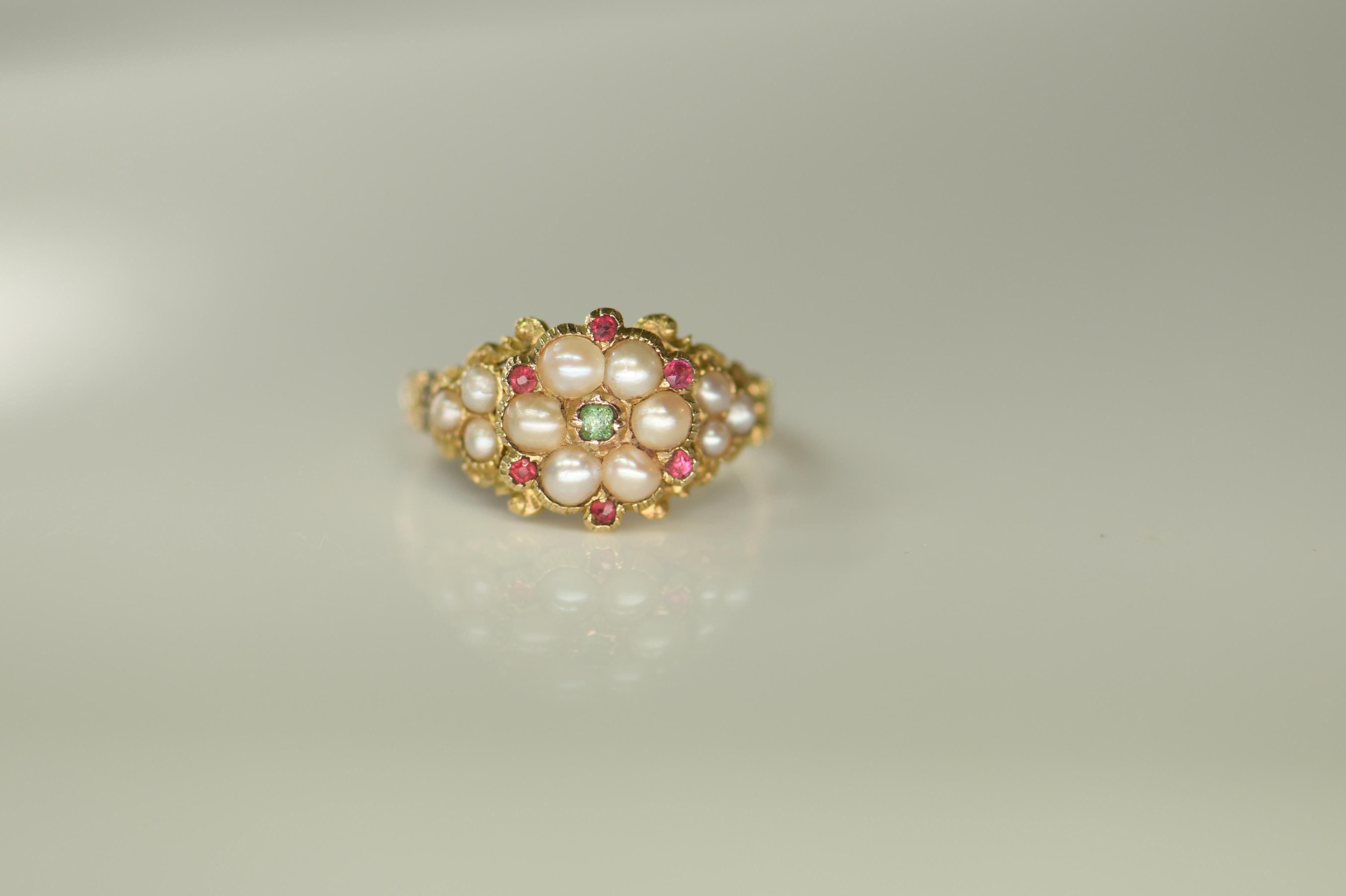 A really lovely 18ct gold Gorigia ring set with four small rubies with four natural split pearls and four smaller ones. In the centre is an emerald. The ring is of quatrefoil design with lovely repousse foliate work in the shoulders. 

Circa