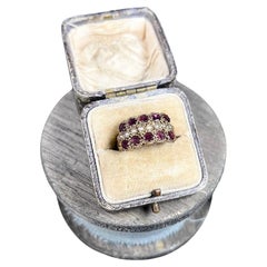 Bague victorienne en or 15ct à trois rangs de grenats et de perles de rocaille avec épaulements à volutes