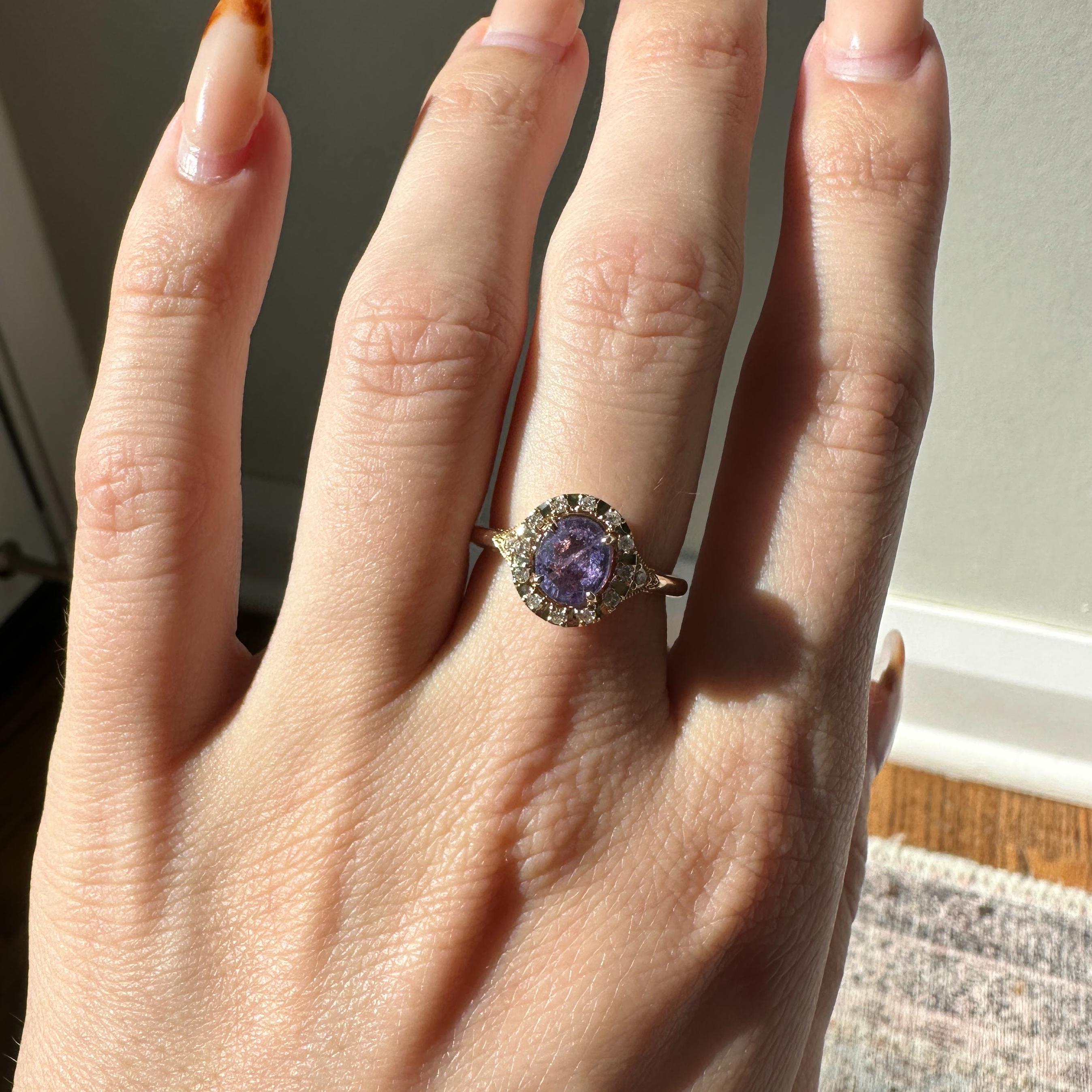 This stunning ring features a 1.58 carat oval Purple Sapphire gemstone, surrounded by a halo of natural earth mined diamonds, all set in solid 14K gold. This Purple Sapphire ring makes a beautiful September birthstone gift for your loved