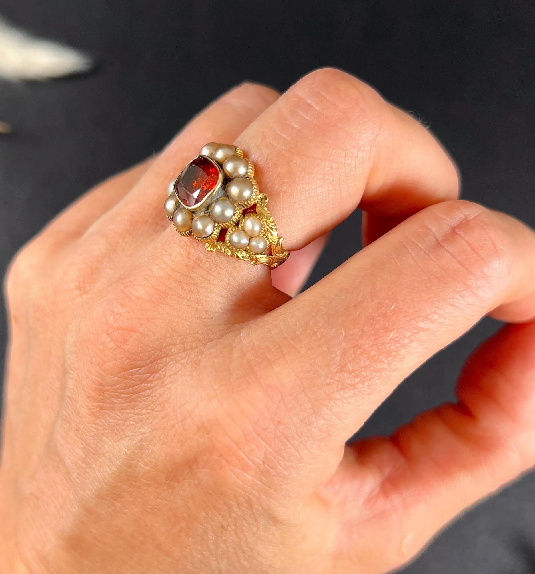 Antique Hessonite Cluster Ring

15ct Gold Tested

Circa 1825

Behold this exquisite 15ct gold Georgian-era ring, featuring a daisy cluster design. At its heart lies a rare hessonite garnet, encircled by natural seed pearls, all nestled within an
