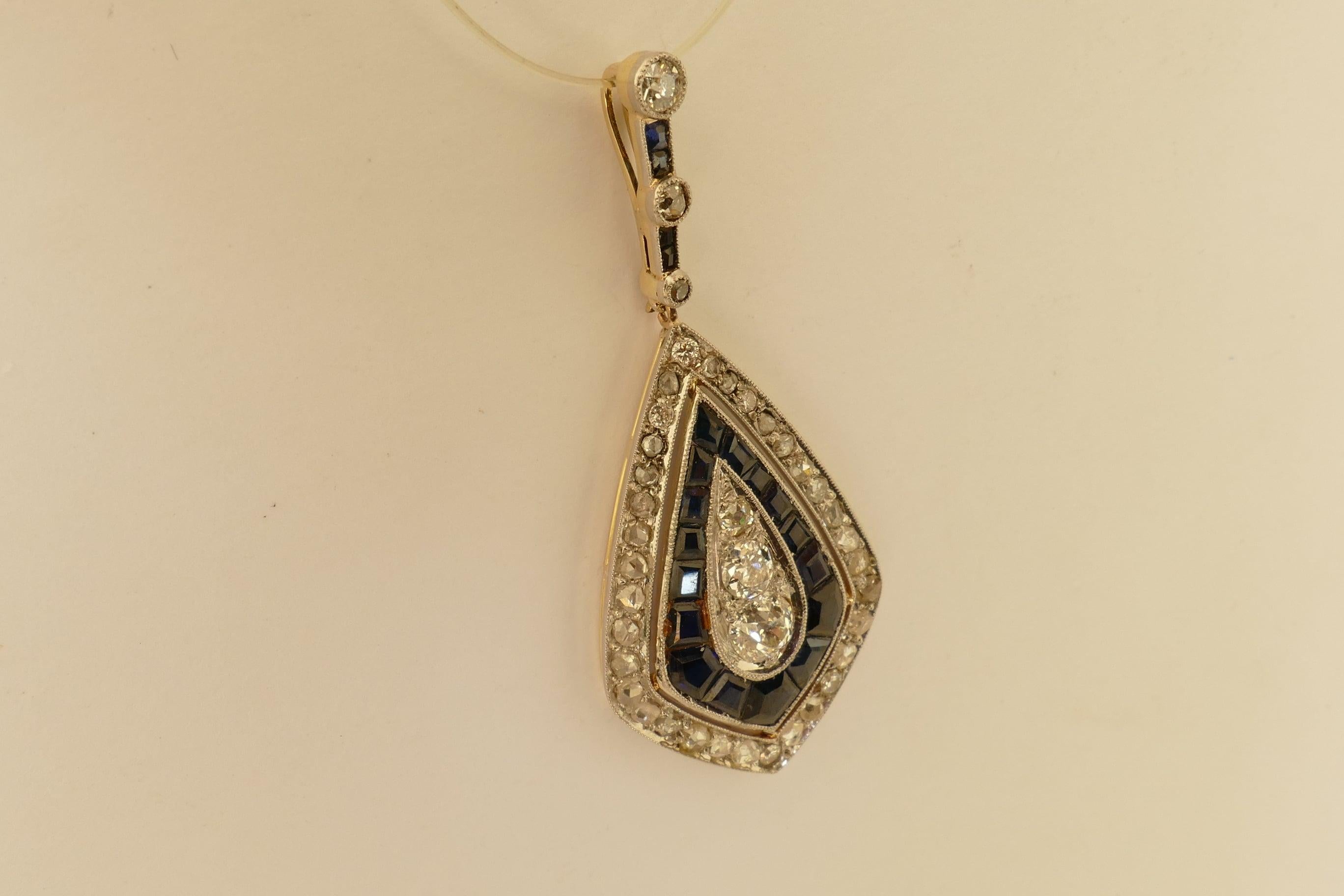 This genuine Art Deco Pendant features 3 Old European Cut Diamonds graduated & totalling half a carat, grain set, Colour F-H, Clarity SI1-SI-2 form the Centrepiece and are surrounded by 16 Royal Blue Colour Sapphires, Tone medium dark, Clarity