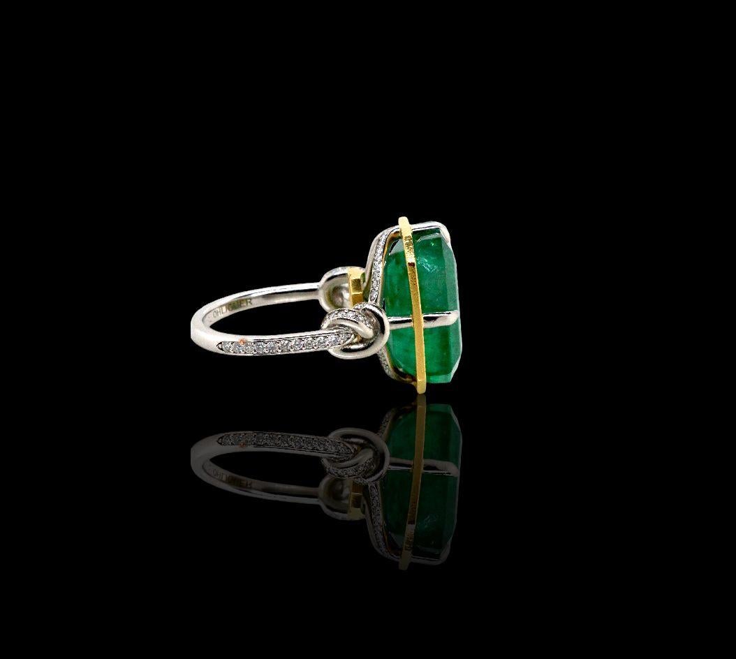 Glamorously bold and unabashedly seductive. This showstopper one of a kind ring features an intense 15ct natural Emerald poised between sharp eagle style talons and embraced by powerful-platinum, diamond encrusted ropes, converging to two knots on